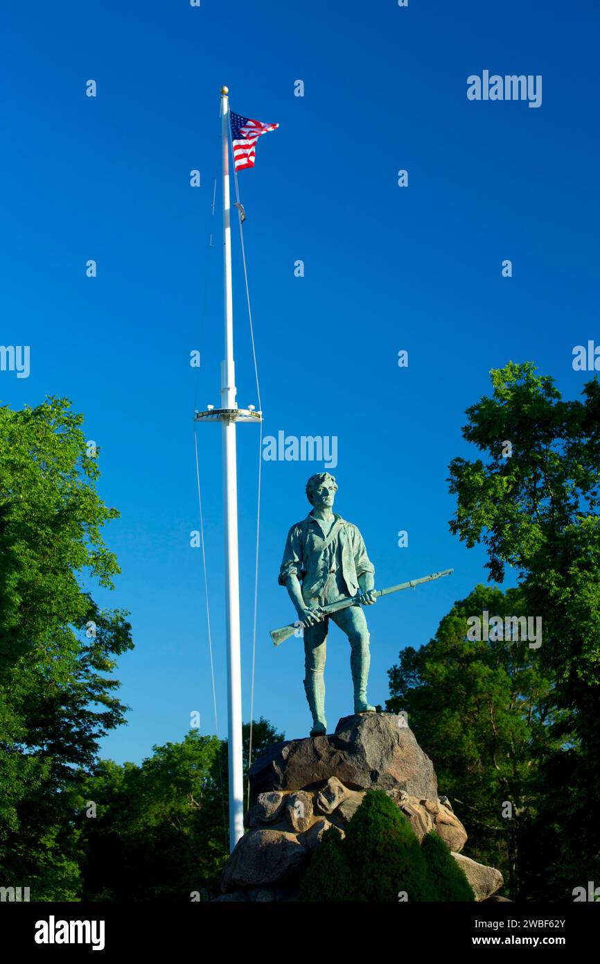 Le Capitaine Parker statue sur Battle Green avec le drapeau américain, Lexington Green, Lexington, Massachusetts Banque D'Images