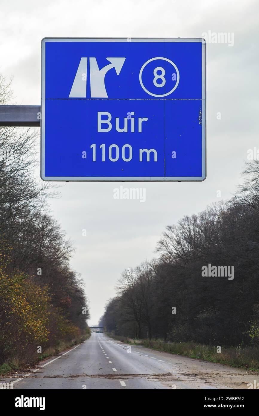 Un panneau de signalisation avec une flèche directionnelle pointe vers la sortie d'autoroute Buir sous un ciel bleu, autoroute A4 abandonnée, lieu perdu, Buir, Kerpen, Nord Banque D'Images