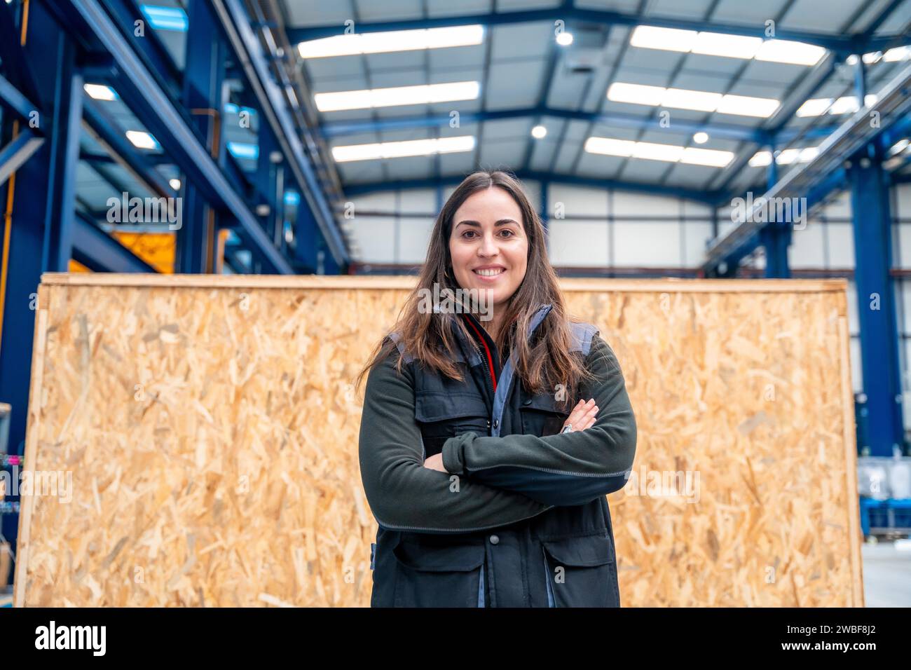 Travailleuse fière avec les bras croisés dans une usine Banque D'Images