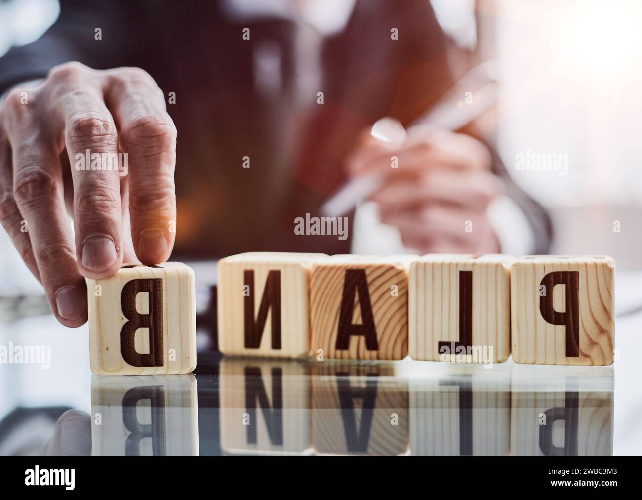 PLAN B, le mot est écrit sur des cubes en bois sur le fond d'un homme d'affaires dans un costume noir à une table. Banque D'Images