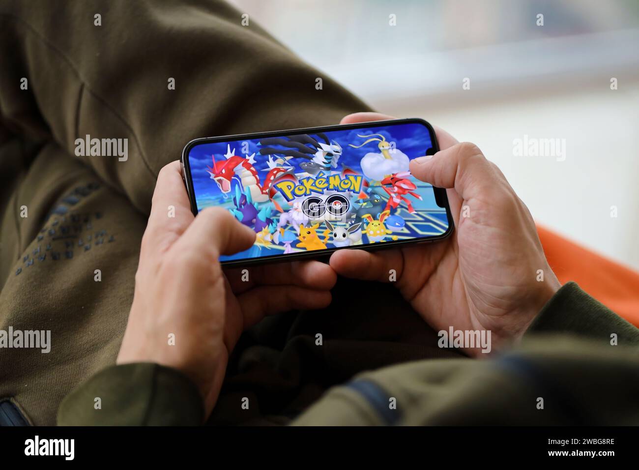 Pokemon GO jeu iOS mobile sur iPhone 15 écran de smartphone dans les mains masculines pendant le jeu mobile. Jeux et divertissements mobiles sur un appareil portable Banque D'Images