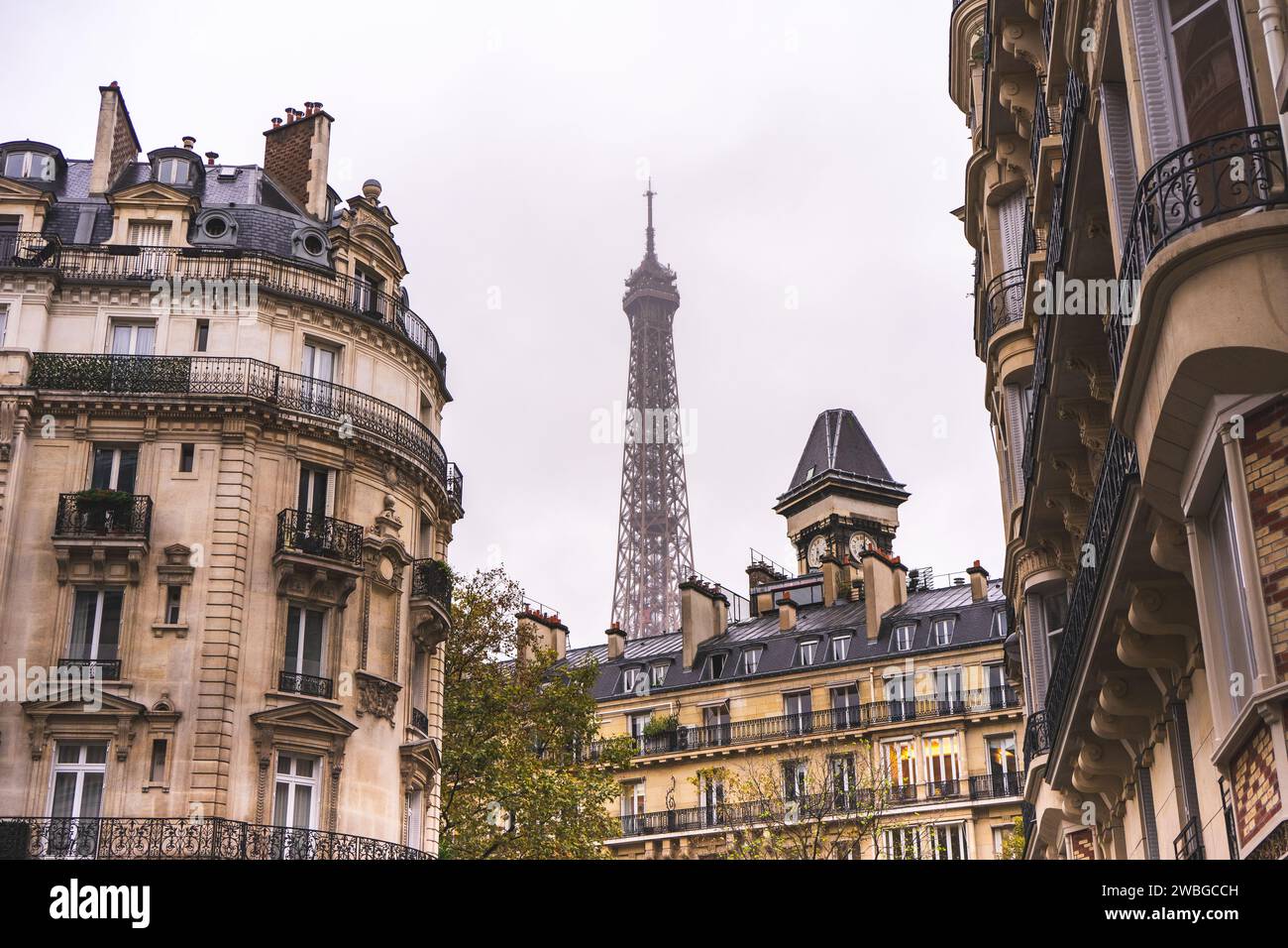 Haut de la tour Eiffeltower avec des bâtiments anciens au premier plan. Paris, France, 22 octobre 2023. Banque D'Images
