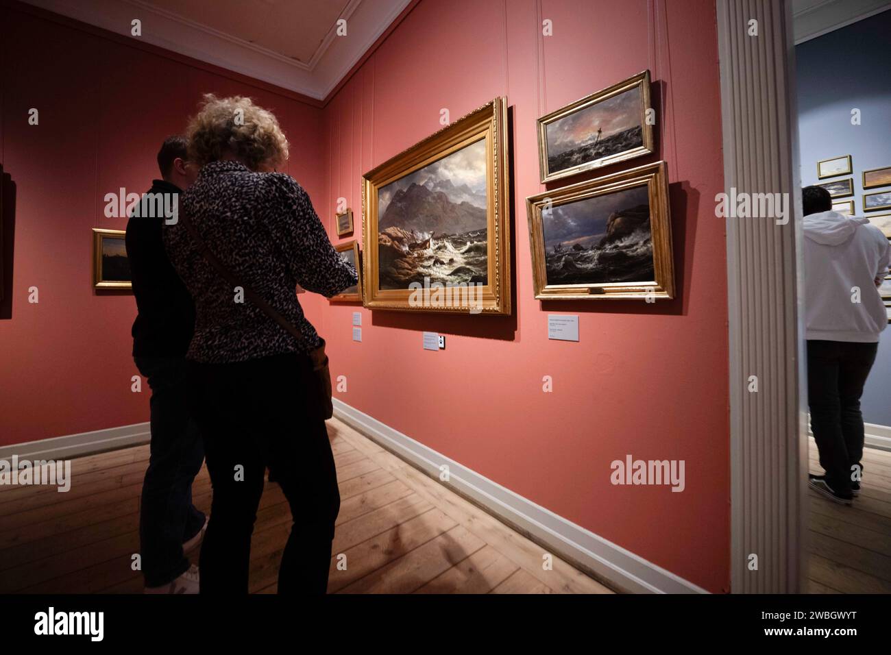 Deux personnes regardent quelques tableaux dans la salle dédiée à l'artiste Johan Christian Clausen au musée Rasmus Meyer. La collection Rasmus Meyer fait partie du musée d'art de Bergen et abrite une importante collection d'œuvres d'artistes norvégiens. Le musée est logé dans une maison historique dans le centre de la ville et est nommé d'après le marchand distingué R Meyer, qui a fait don de sa collection d'art privée à la ville en 1911. La collection comprend des œuvres de divers artistes du 19e et du début du 20e siècle, avec un accent particulier sur Edvard Munch. Il y a aussi des peintures, des dessins et des gravures par OT Banque D'Images