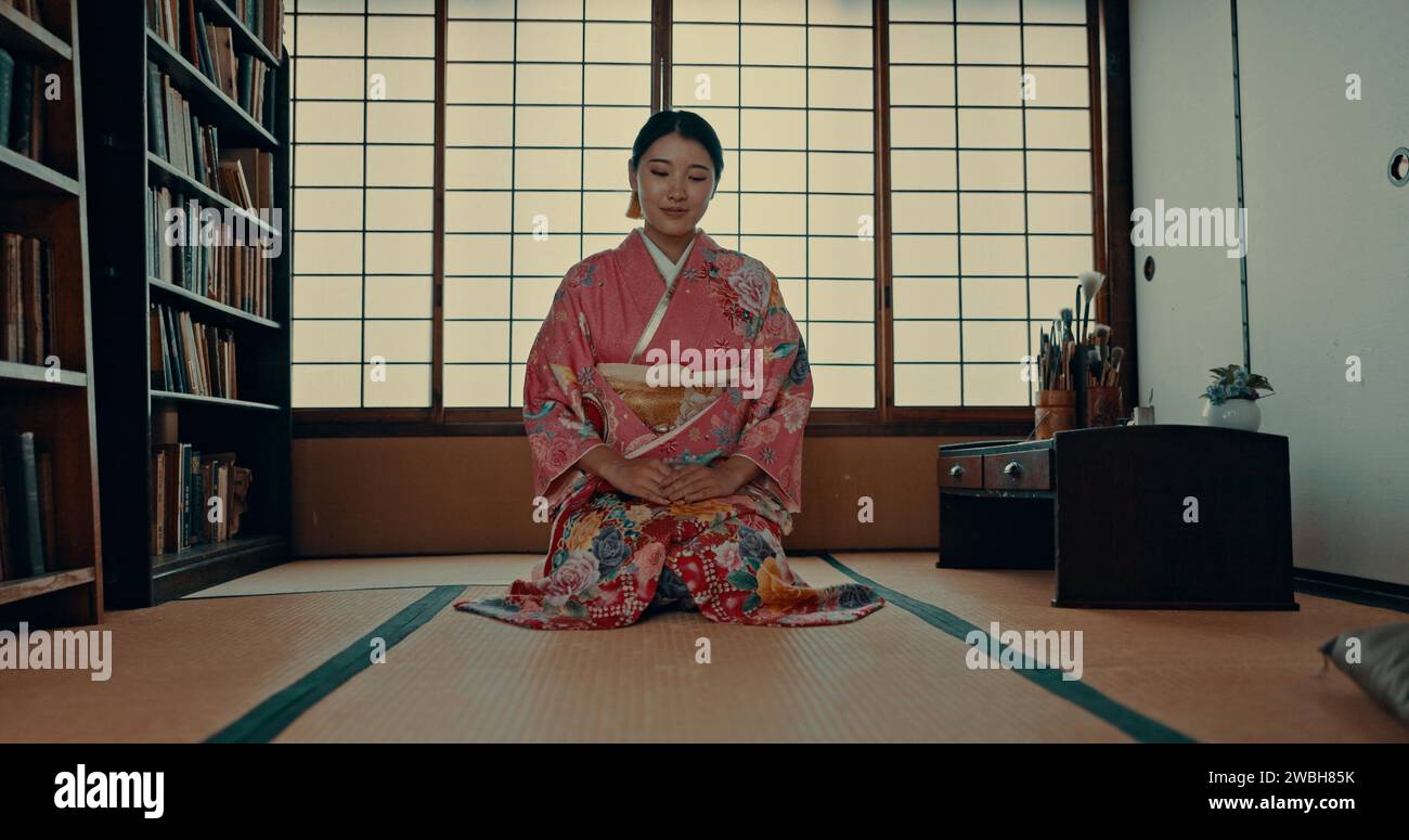 Femme, japonais et bien-être spirituel dans une salle traditionnelle de tatami pour la culture zen, la gratitude ou le rituel. Personne asiatique, genou et kimono pour la pleine conscience Banque D'Images