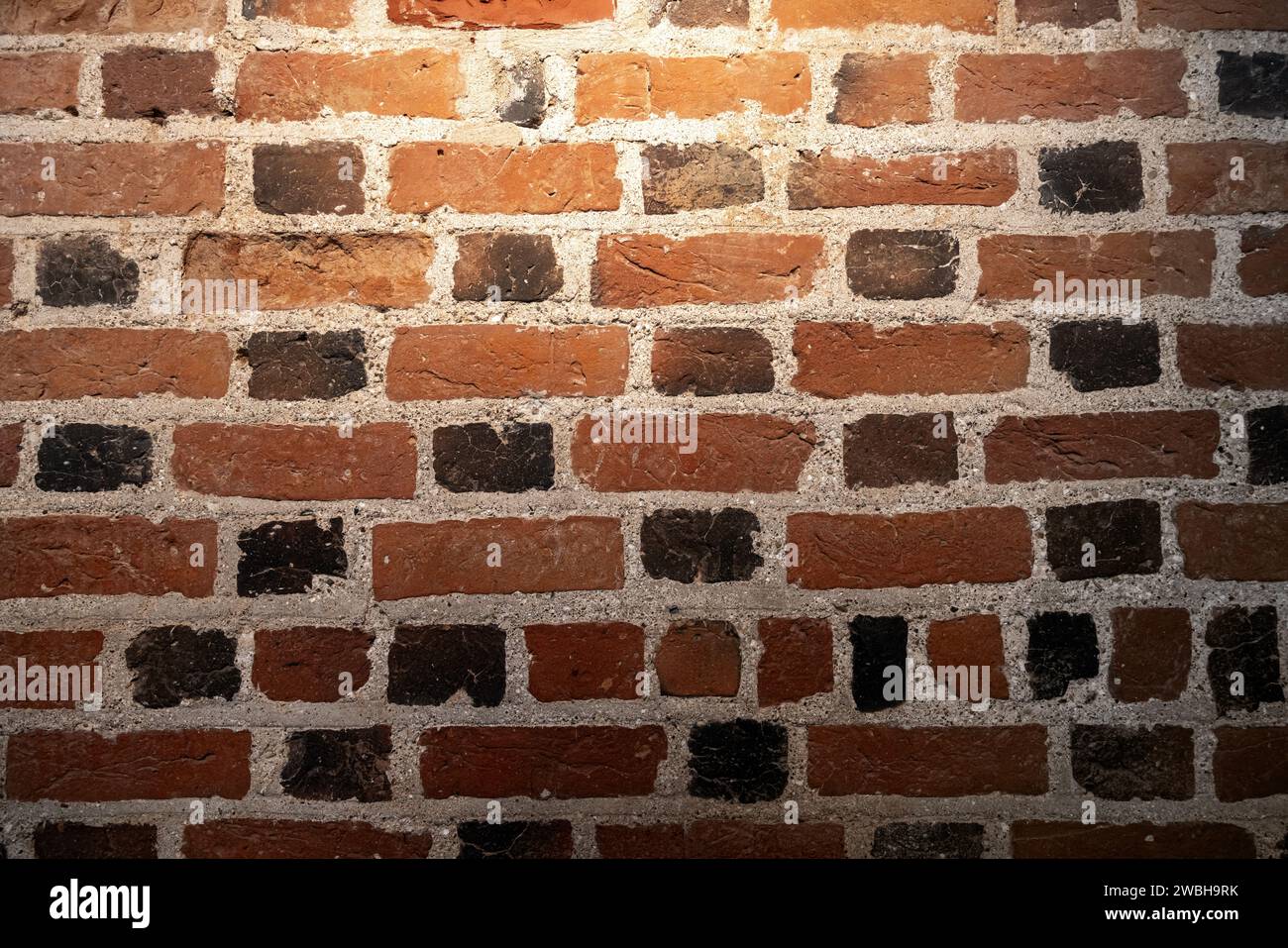 Mur de brique sombre grungy avec projecteur, texture de photo de fond Banque D'Images