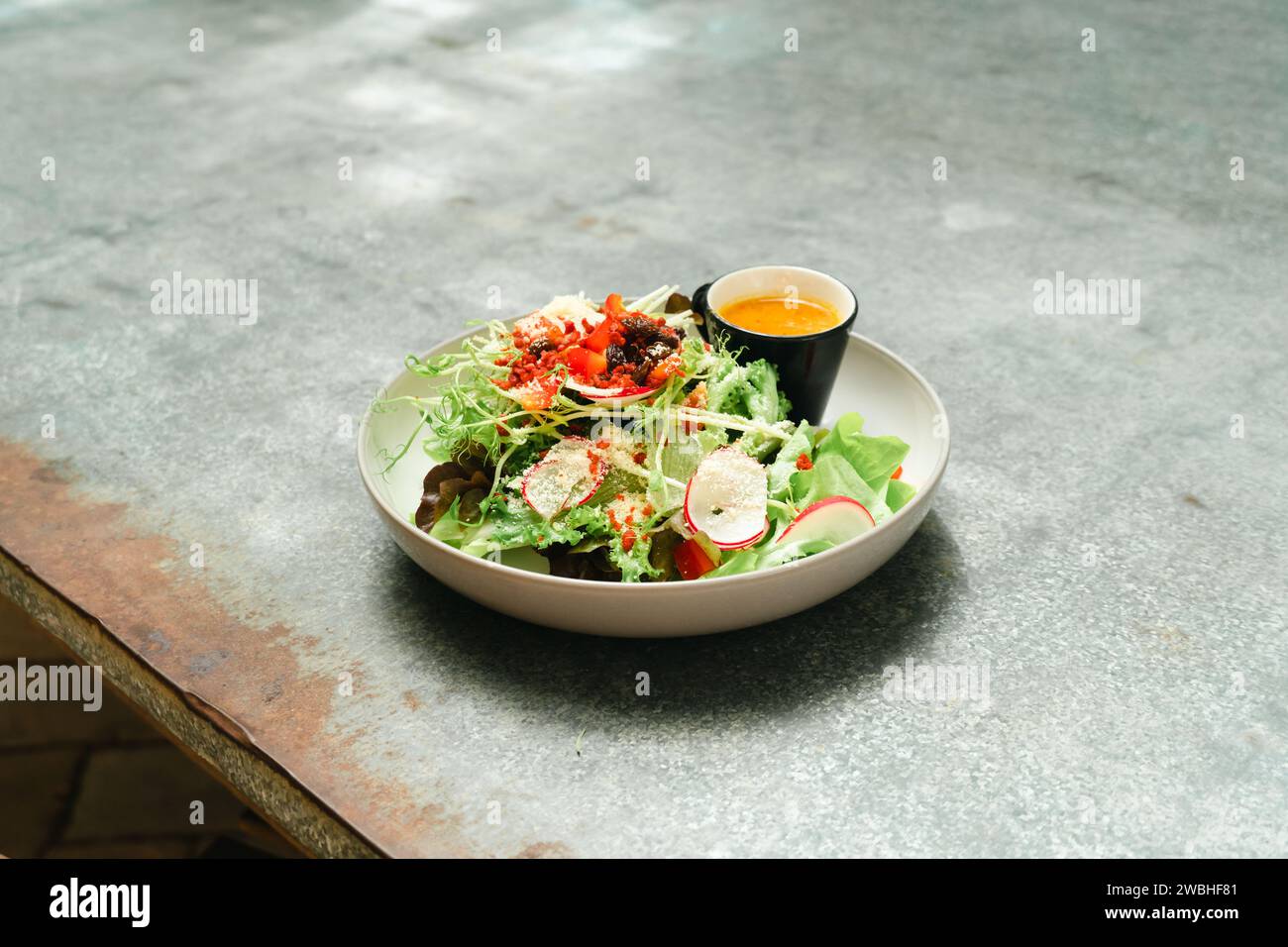 Salade végétalienne verte fraîche à base de feuilles vertes mélangées et de légumes. Vue de dessus sur la table en pierre grise. Salade grecque de concombre frais, tomate, poivron, lettu Banque D'Images
