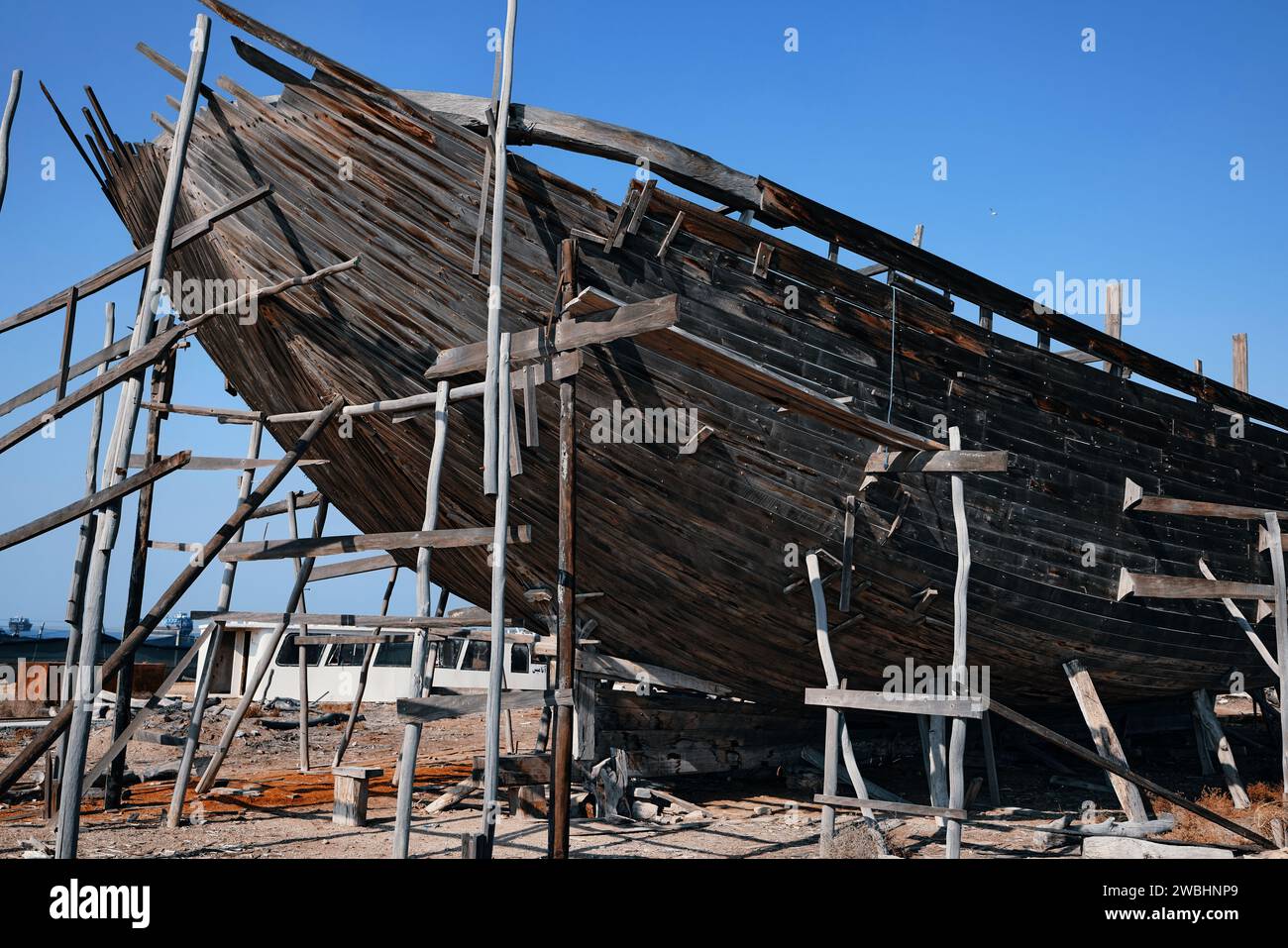 Construction d'un navire en bois. Chantier naval de bateau traditionnel en bois Dhow sur l'île iranienne de Qeshm. Tradition Lenj bateau de pêche à Qeshm Island in Banque D'Images