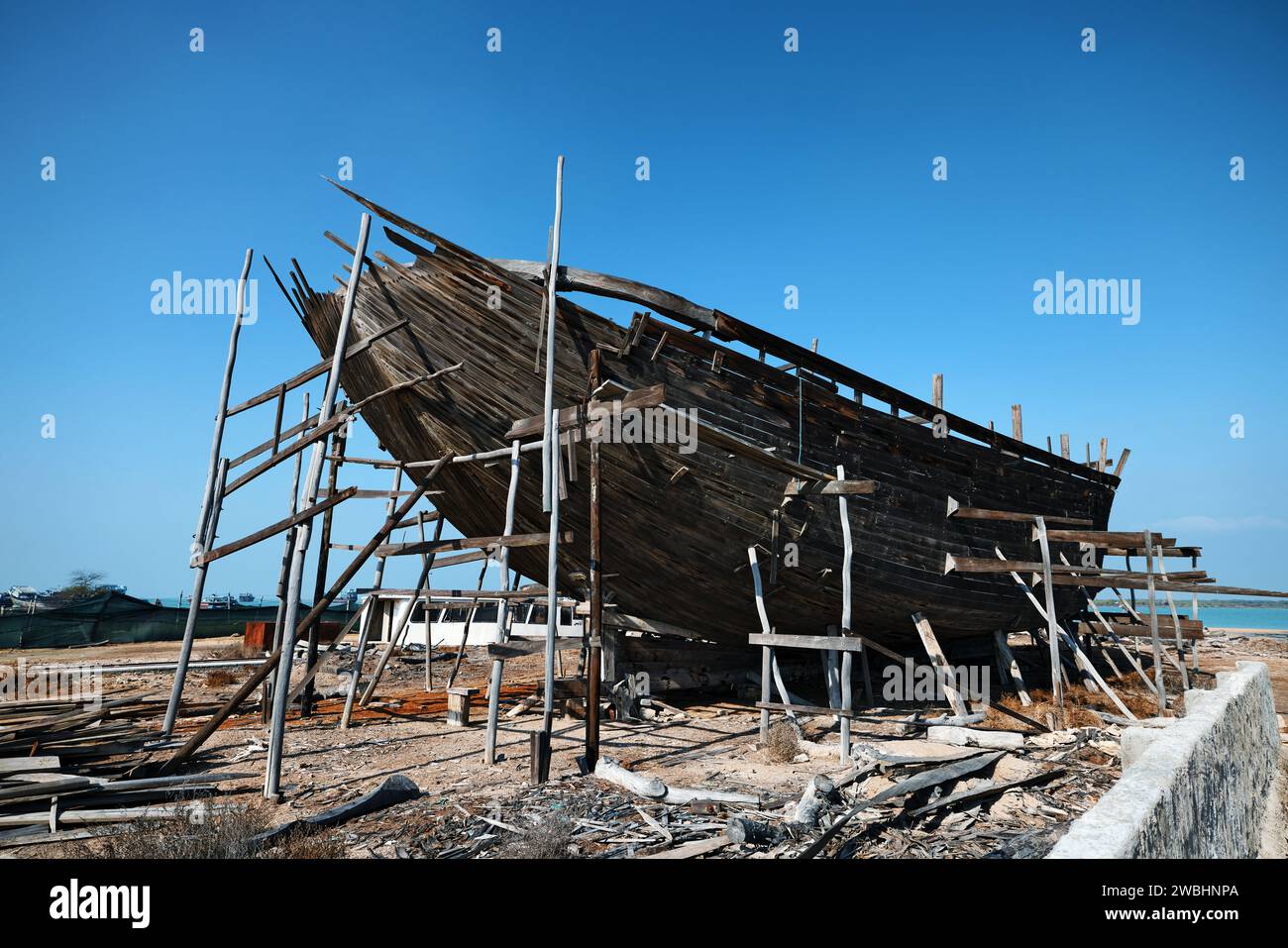 Construction d'un navire en bois. Chantier naval de bateau traditionnel en bois Dhow sur l'île iranienne de Qeshm. Tradition Lenj bateau de pêche à Qeshm Island in Banque D'Images