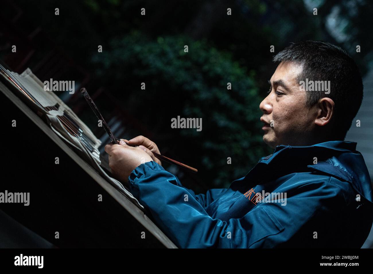 (240111) -- CHONGQING, 11 janv. 2024 (Xinhua) -- Yu Dahong grave sur un peigne en bois dans un atelier de l'usine Tanmujiang à Chongqing, dans le sud-ouest de la Chine, le 5 janvier 2024. L'artisanat traditionnel de fabrication de peigne en bois de Tanmujiang, qui combine l'habileté de la décoration de couleur, de la gravure, du laquage et de la dorure d'or, a été classé comme patrimoine culturel immatériel de la municipalité de Chongqing. En utilisant du buis, de l'ébène ou du bois de santal comme matériaux pour sculpter des motifs tels que des personnages, des fleurs et des oiseaux sur les peignes, l'artisanat a transformé l'article commun dans la vie quotidienne en une œuvre d'art avec des valeurs esthétiques. Banque D'Images