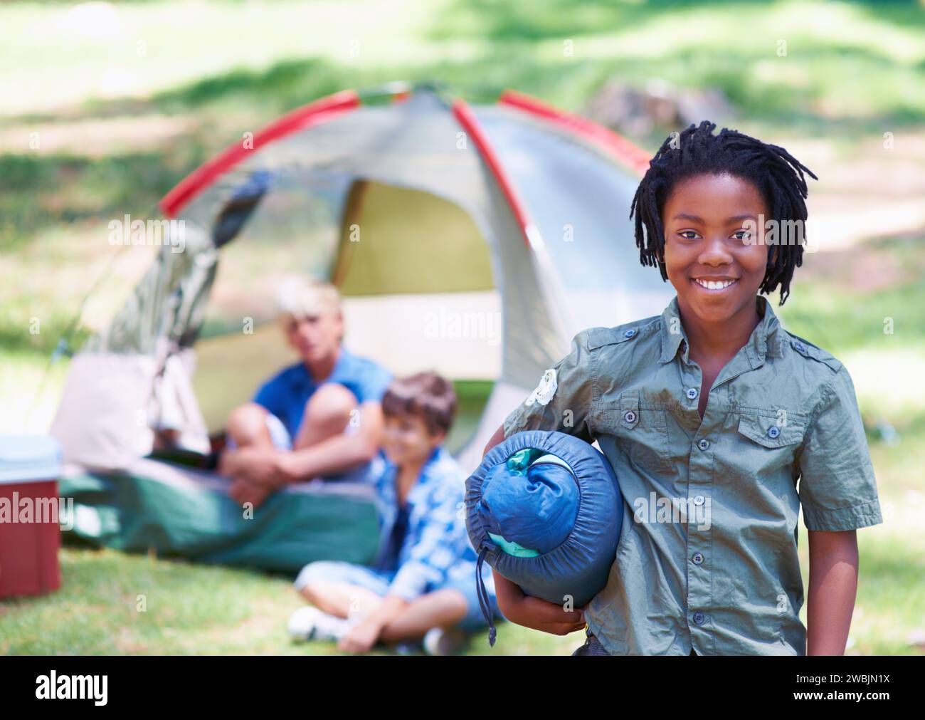 Sac de couchage, camping ou portrait d'enfant africain dans la nature sur l'aventure ou des vacances dans le parc. Heureux, commencer ou garçon avec le sourire dans la forêt, le jardin Banque D'Images