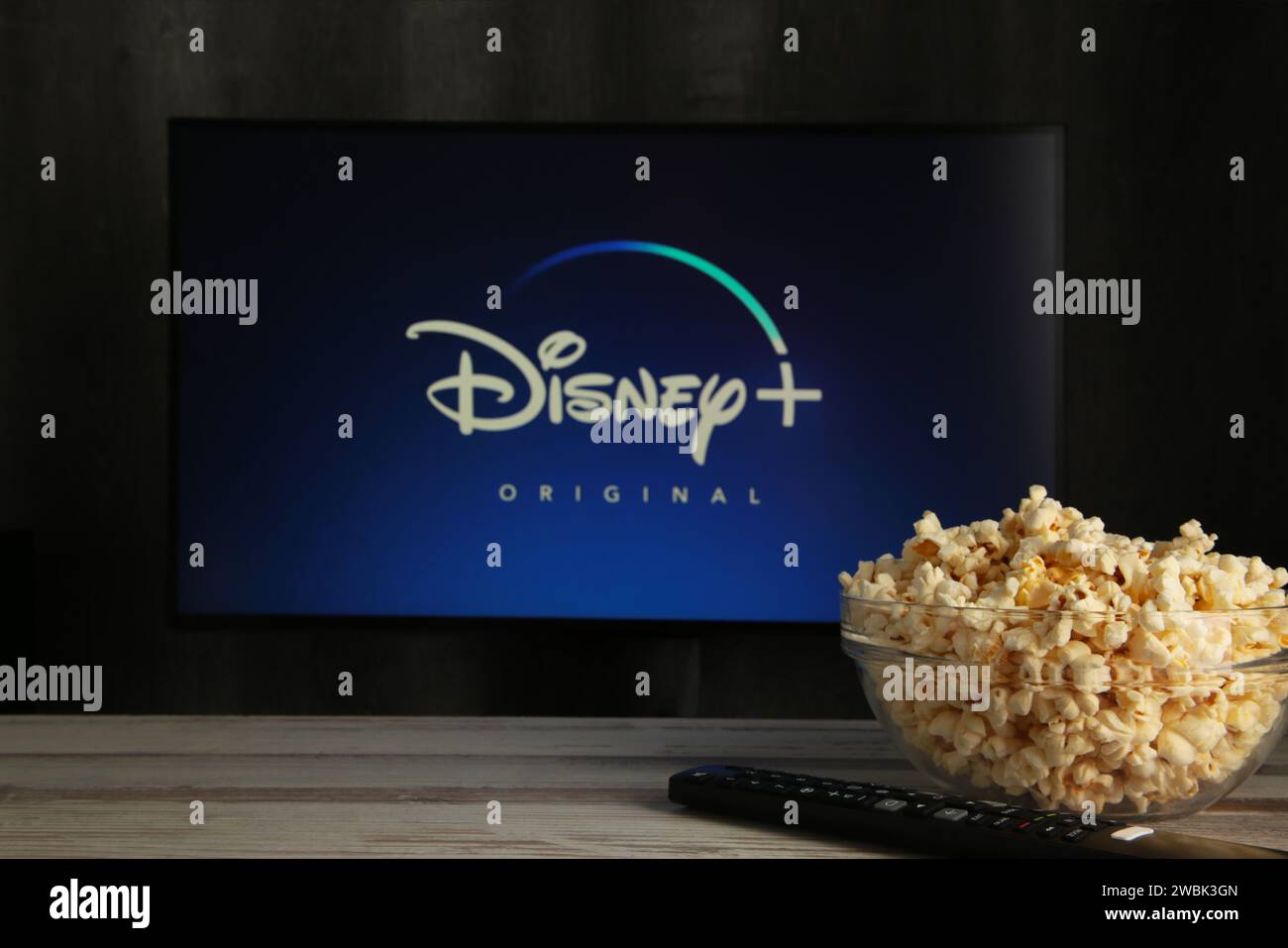 Nikolaev, Ukraine - 20 novembre 2021. Un homme tient une télécommande Disney avec un nouvel écran sur un téléviseur pop-corn. Disney est un abonnement de streaming vidéo en ligne Banque D'Images