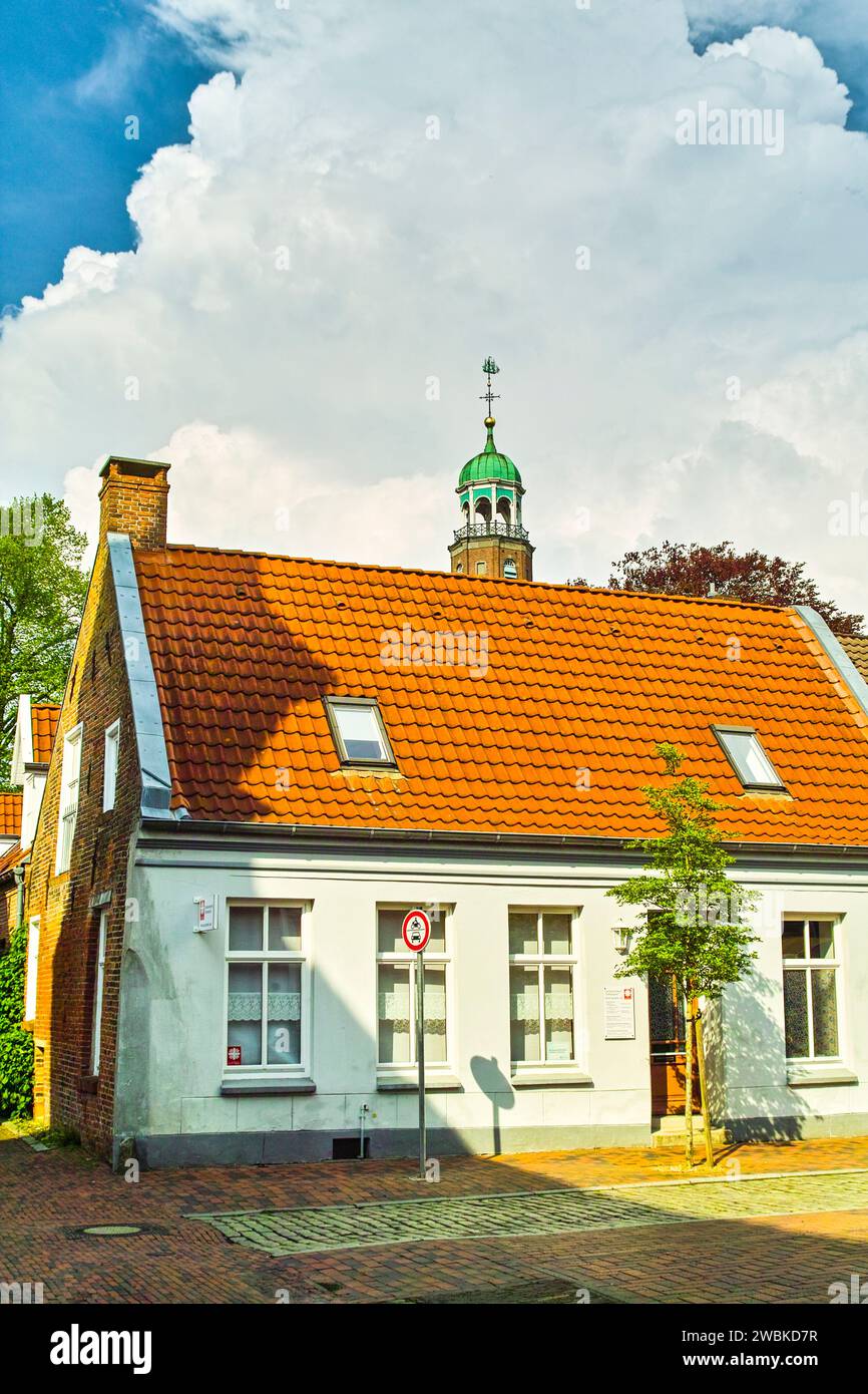 Vieille ville idyllique à Leer, la flèche de la grande église jette un œil sur une vieille maison de ville confortable Banque D'Images