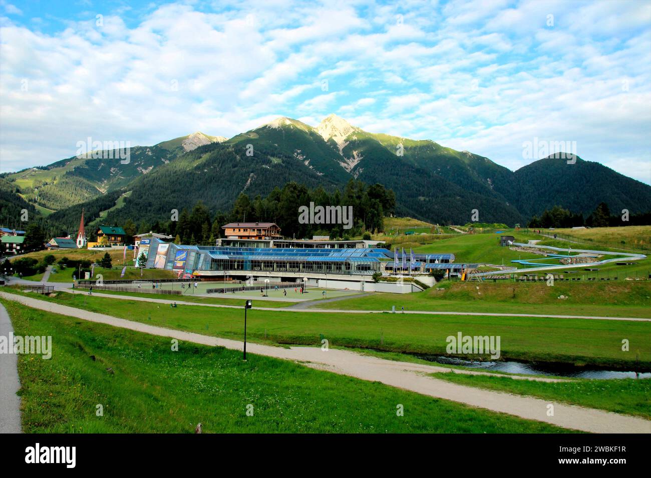 Autriche, Tyrol, Seefeld, vue locale, centre de congrès, court de tennis, terrain de volley-ball, centre de loisirs, piscine, sauna, Tyrol du Nord, gens, sport, vacances, vacances d'été, bâtiment événementiel, vue montagne, Alpes, Reitherspitze, Seefelderspitze, destination, tourisme Banque D'Images