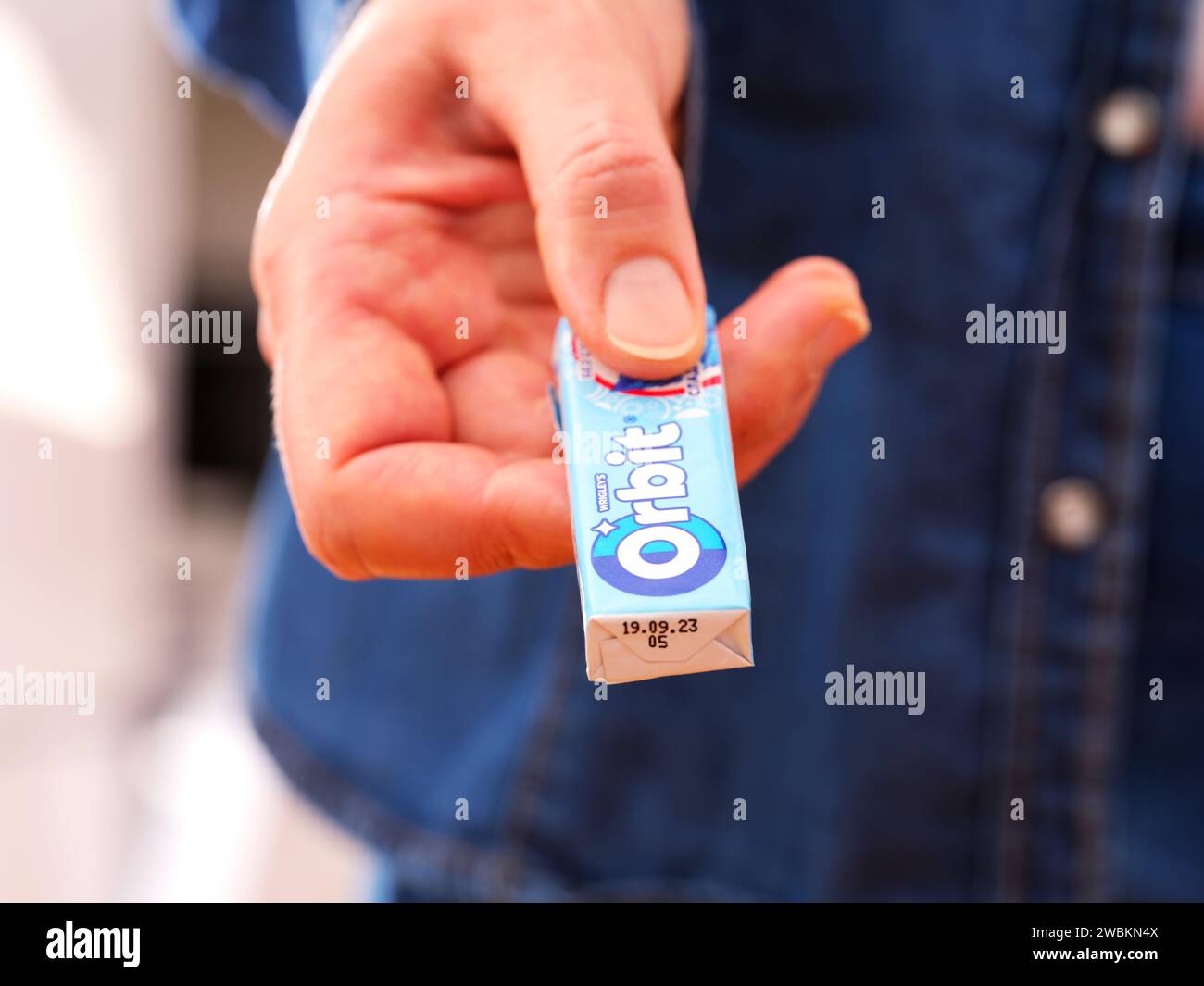 Tambov, Fédération de Russie - 20 décembre 2023 Une femme donne un paquet de chewing-gum Orbit de Wrigley. Banque D'Images