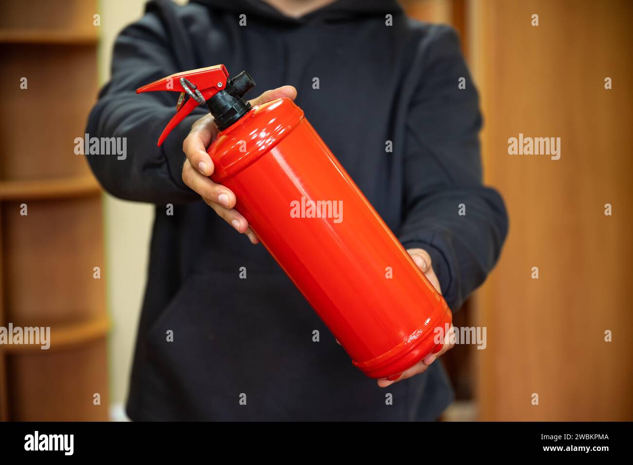 Un homme tient un extincteur dans le bureau. Le concept de sécurité incendie Banque D'Images