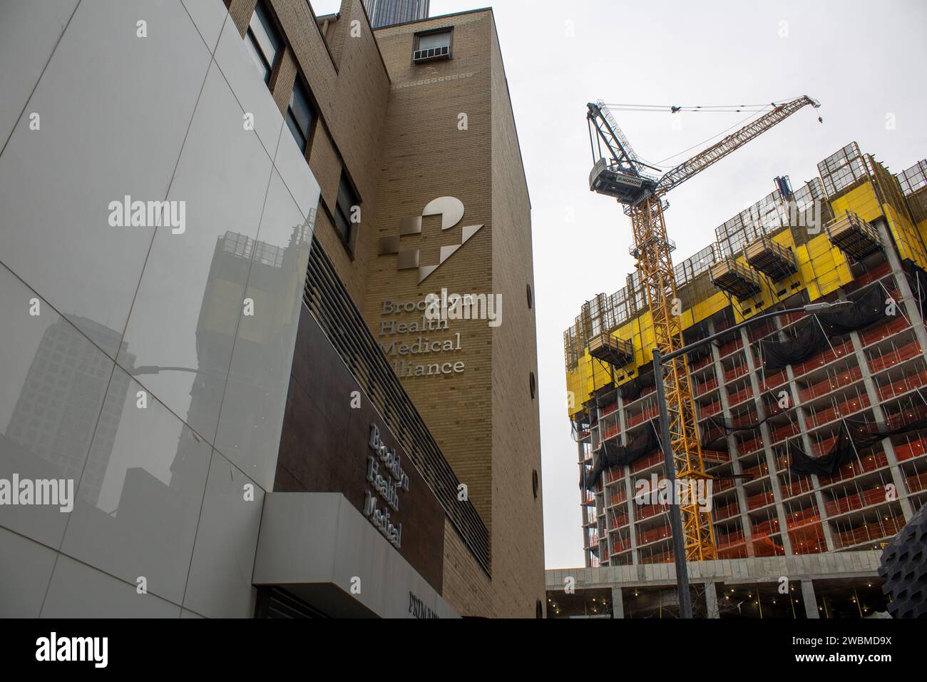 Une vue architecturale d'un immeuble moderne de grande hauteur avec plusieurs grues au premier plan devant un chantier de construction Banque D'Images