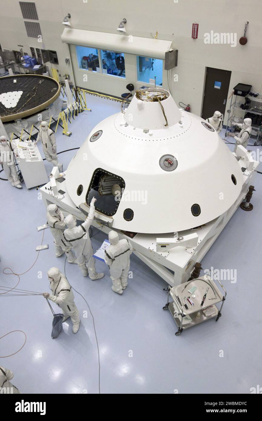 CAP CANAVERAL, Floride. – Dans le Payload Hazardous Servicing Facility du Kennedy Space Center de la NASA en Floride, les techniciens se tiennent à côté de la mission Aeroshell du Mars Science Laboratory (MSL) de la NASA, tandis qu’au premier plan, un technicien guide la scène de croisière sur un stand de rotation. La phase de croisière fournit de l'énergie solaire, des propulseurs pour la navigation et des échangeurs de chaleur au rover pendant son vol de la Terre à Mars. À l'arrière gauche se trouve l'écran thermique MSL. Les composants de MSL comprennent un rover de la taille d'une voiture, Curiosity, qui dispose de 10 instruments scientifiques conçus pour rechercher des preuves pour savoir si Mars a eu l'envir Banque D'Images
