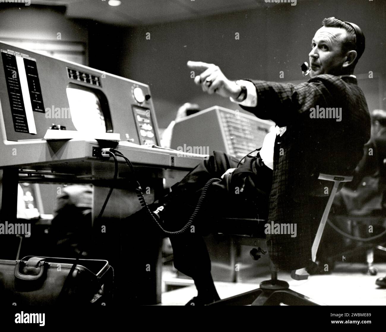 Christopher Kraft, le directeur de vol du projet Mercury, opère à sa console dans Mercury Mission Control, coordonnant les activités de la mission et surveillant les systèmes des engins spatiaux. Banque D'Images
