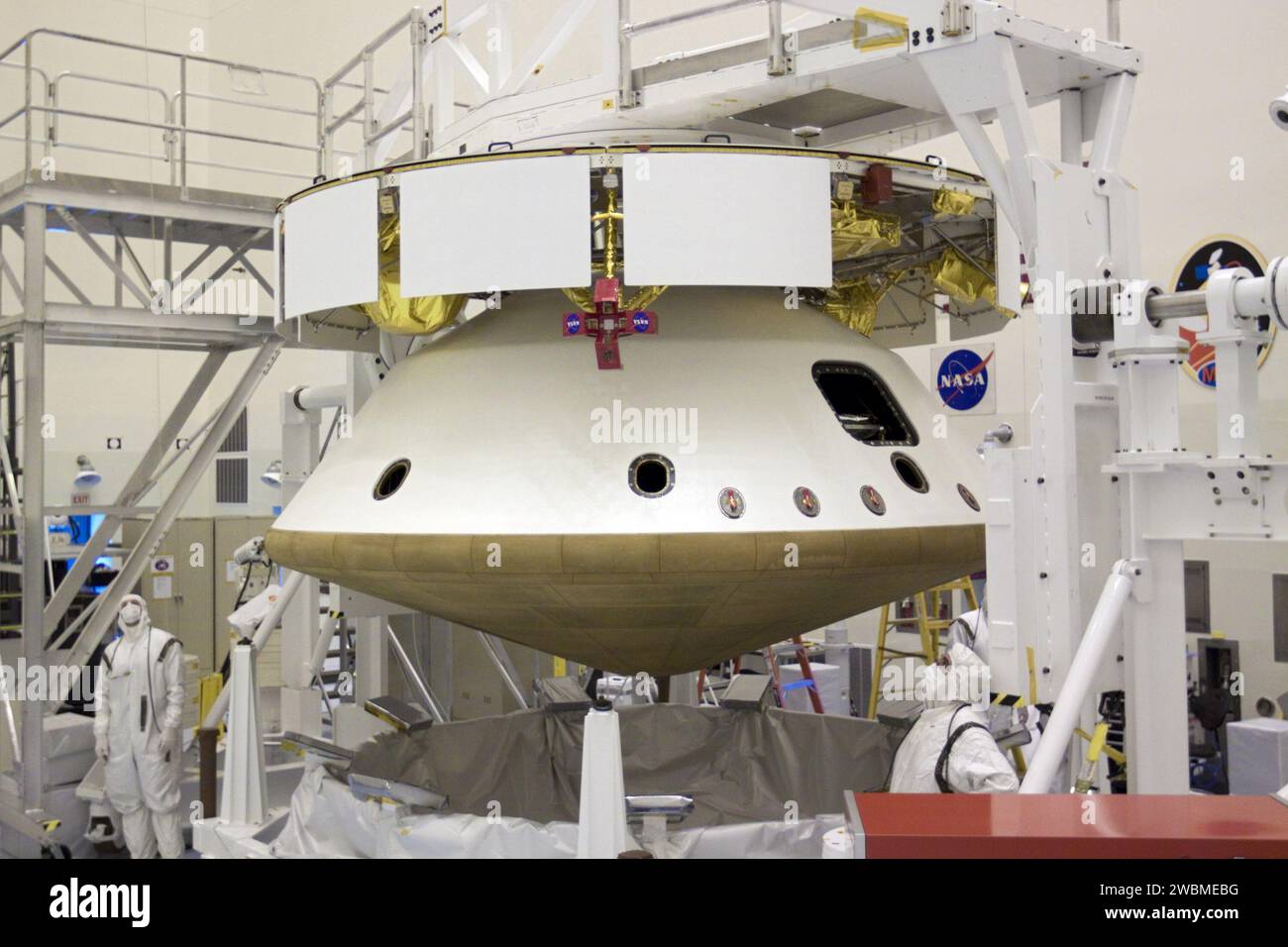 CAP CANAVERAL, Floride. – Dans l’installation d’entretien des charges utiles dangereuses du Kennedy Space Center de la NASA en Floride, les techniciens observent le levage d’un pont roulant. La grue a été utilisée pour intégrer le bouclier thermique à la mission Aeroshell du Mars Science Laboratory (MSL) de la NASA (contenant le rover Curiosity). Plus tôt, l'aéroshell a été accouplé à l'étage de croisière, qui fournit de l'énergie solaire, des propulseurs pour la navigation et des échangeurs de chaleur au rover pendant son vol de la Terre à Mars. Le rover Curiosity dispose de 10 instruments scientifiques conçus pour rechercher des preuves sur le fait que Mars h Banque D'Images