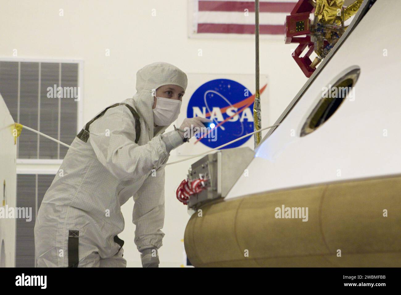 CAP CANAVERAL, Floride. – Dans l’installation d’entretien des charges utiles dangereuses du Kennedy Space Center de la NASA en Floride, un technicien inspecte l’alignement du bouclier thermique après intégration avec la mission Aeroshell du Mars Science Laboratory (MSL) de la NASA (contenant le rover Curiosity compact de la taille d’une voiture). Plus tôt, l'aéroshell a été accouplé à l'étage de croisière, qui fournit de l'énergie solaire, des propulseurs pour la navigation et des échangeurs de chaleur au rover pendant son vol de la Terre à Mars. Le rover Curiosity dispose de 10 instruments scientifiques conçus pour rechercher des preuves sur le fait que Mars a eu des environnements favorables Banque D'Images