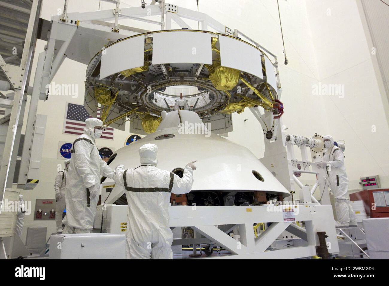 CAP CANAVERAL, Floride. – Dans l’installation d’entretien des charges utiles du Kennedy Space Center de la NASA en Floride, les techniciens se préparent à fixer un pont roulant à la mission Aeroshell du Mars Science Laboratory (MSL) de la NASA (contenant le rover Curiosity compact de la taille d’une voiture), qui sera couplé à la phase de croisière. La phase de croisière fournit de l'énergie solaire, des propulseurs pour la navigation et des échangeurs de chaleur au rover pendant son vol de la Terre à Mars. Le rover Curiosity dispose de 10 instruments scientifiques conçus pour rechercher des preuves sur le fait que Mars a eu des environnements favorables à la vie microbienne, y compris Banque D'Images