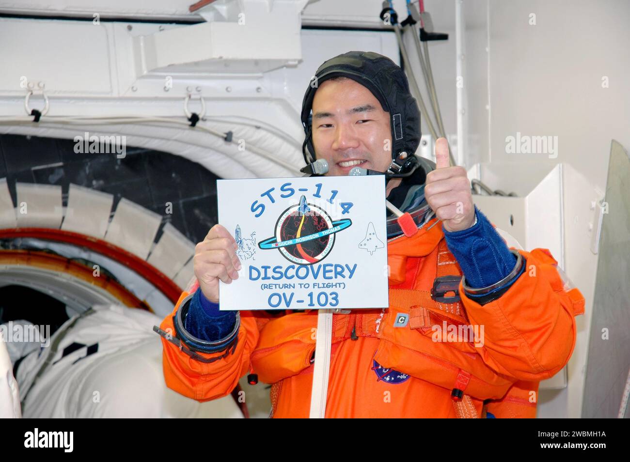 Soichi Noguchi, spécialiste de mission de la JAXA, détient le patch de mission pour la mission de retour en vol STS-114 de la navette spatiale Discovery à destination de l’ISS. L'équipage a effectué les répétitions du test de démonstration du compte à rebours terminal, y compris la formation sur le compte à rebours et l'évacuation d'urgence. La période de lancement est du 13 au 31 juillet. Banque D'Images