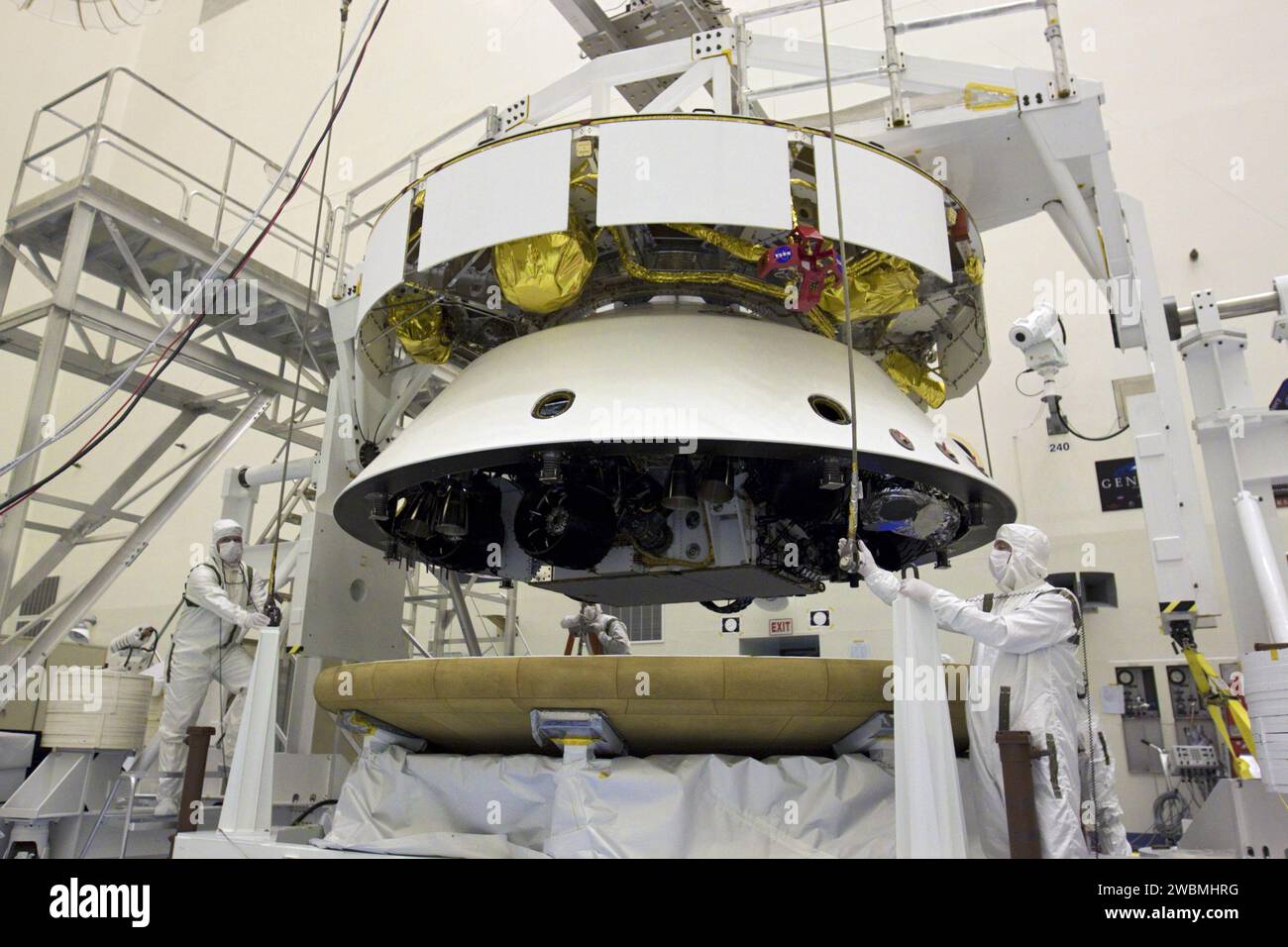 CAP CANAVERAL, Floride. – Dans l’installation d’entretien des charges utiles dangereuses du Kennedy Space Center de la NASA en Floride, les techniciens attachent un pont roulant au bouclier thermique en préparation de l’intégration avec la mission Aeroshell du Mars Science Laboratory (MSL) de la NASA (contenant le rover Curiosity compact de la taille d’une voiture). Plus tôt, l'aéroshell a été accouplé à l'étage de croisière, qui fournit de l'énergie solaire, des propulseurs pour la navigation et des échangeurs de chaleur au rover pendant son vol de la Terre à Mars. Le rover Curiosity dispose de 10 instruments scientifiques conçus pour rechercher des preuves sur l'environnement de Mars Banque D'Images