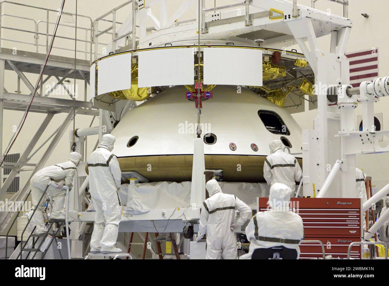CAP CANAVERAL, Floride. – Dans le Payload Hazardous Servicing Facility du Kennedy Space Center de la NASA en Floride, les techniciens surveillent l’alignement du bouclier thermique lorsqu’un pont roulant le soulève pour l’intégrer à la mission Aeroshell du Mars Science Laboratory (MSL) de la NASA (contenant le rover Curiosity compact de la taille d’une voiture). Plus tôt, l'aéroshell a été accouplé à l'étage de croisière, qui fournit de l'énergie solaire, des propulseurs pour la navigation et des échangeurs de chaleur au rover pendant son vol de la Terre à Mars. Le rover Curiosity dispose de 10 instruments scientifiques conçus pour rechercher des preuves sur Mars Banque D'Images