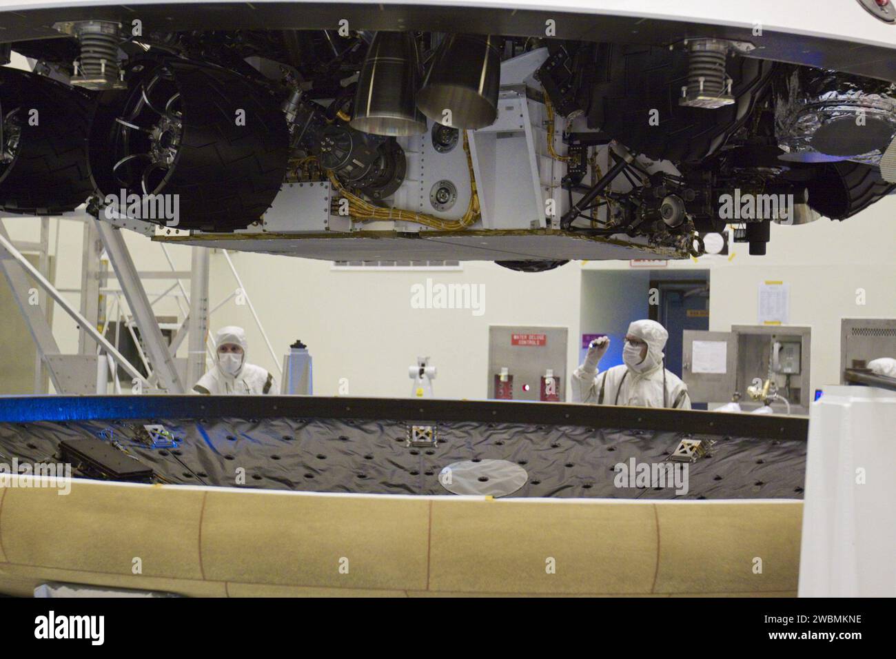 CAP CANAVERAL, Floride. – Dans l’installation d’entretien des charges utiles dangereuses du Kennedy Space Center de la NASA en Floride, les techniciens inspectent le bouclier thermique en préparation de son intégration avec la mission Aeroshell du Mars Science Laboratory (MSL) de la NASA (contenant le rover Curiosity compact de la taille d’une voiture). Plus tôt, l'aéroshell a été accouplé à l'étage de croisière, qui fournit de l'énergie solaire, des propulseurs pour la navigation et des échangeurs de chaleur au rover pendant son vol de la Terre à Mars. Le rover Curiosity dispose de 10 instruments scientifiques conçus pour rechercher des preuves sur le fait que Mars a eu des environnements favorables à l'IM Banque D'Images