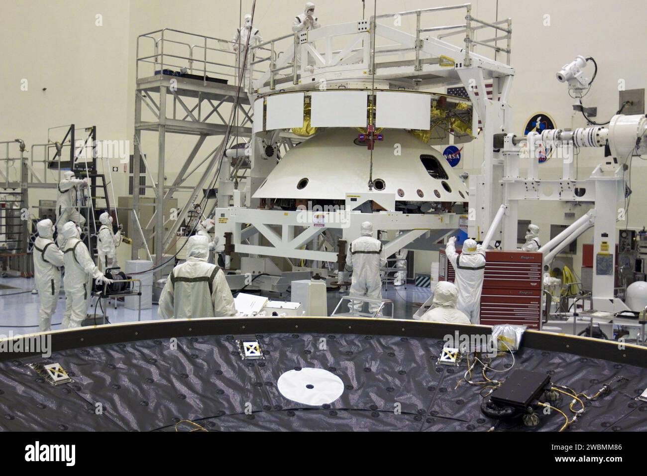 CAP CANAVERAL, Floride. – Dans le Payload Hazardous Servicing Facility du Kennedy Space Center de la NASA en Floride, les techniciens, à l’aide d’un pont roulant, soulèvent la mission Aeroshell du Mars Science Laboratory (MSL) de la NASA, (contenant le rover Curiosity compact de la taille d’une voiture), pour s’accoupler à la scène de croisière. La phase de croisière fournit de l'énergie solaire, des propulseurs pour la navigation et des échangeurs de chaleur au rover pendant son vol de la Terre à Mars. Au premier plan se trouve l'écran thermique MSL. Le rover Curiosity dispose de 10 instruments scientifiques conçus pour rechercher des preuves sur la question de savoir si Mars a eu des environnements favorables à Banque D'Images