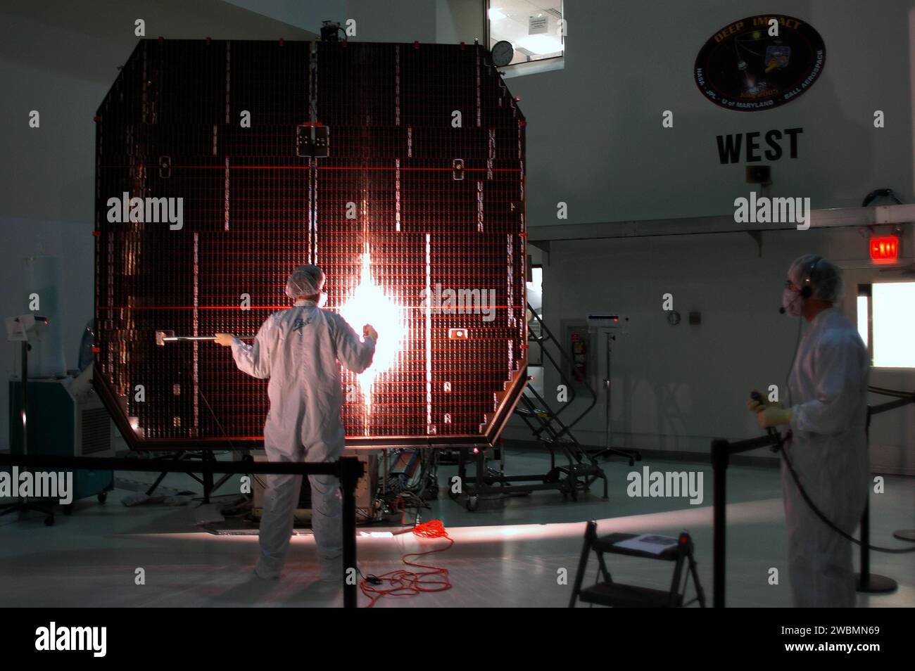 CENTRE SPATIAL KENNEDY, FLA. - Les techniciens d'Astrotech à Titusville, en Floride, effectuent un test d'illumination sur le vaisseau spatial à impact profond comme vérification finale des performances. Le lancement à bord d'une fusée Boeing Delta II depuis Pad 17-B, Cape Canaveral Air Force Station, Floride, est prévu pour janvier 8. La mission Deep impact est la première à explorer l'intérieur d'une comète en utilisant un vaisseau spatial pour créer un cratère, ce qui nous permet de regarder en profondeur à l'intérieur. Des images spectaculaires provenant à la fois de l ' engin spatial survolé et de l ' impacteur seront renvoyées à la Terre lointaine sous forme de données en temps quasi réel. Ces premières vues profondes sous les s d’une comète Banque D'Images
