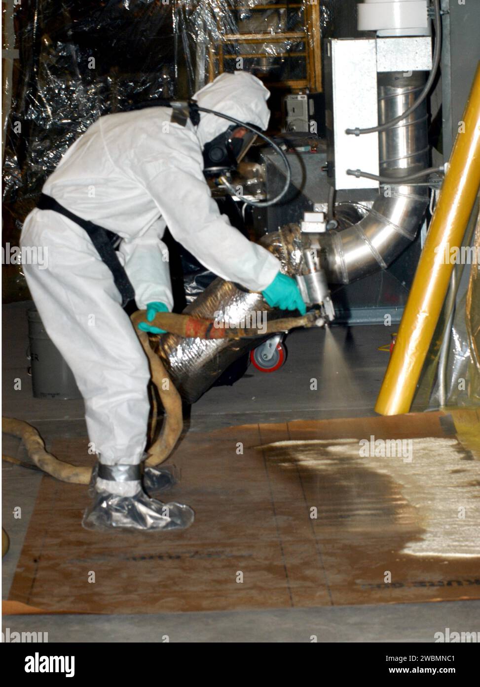 CENTRE SPATIAL KENNEDY, FLA. - Dans le bâtiment de montage des véhicules, Rob Williams, technicien de l ' Alliance spatiale unie, teste le pistolet pulvérisateur avant de commencer la pulvérisation de fermeture à point dur arrière sur le réservoir externe (et). La pulvérisation est appliquée sur une zone du réservoir où l ' et est accouplé au transporteur. La mousse n'est pas appliquée sur cette zone à l'usine de montage Michoud en Louisiane pour éviter d'endommager la mousse pendant le voyage. L'et, qui est arrivé au KSC le 5 janvier, est dans la cellule de vérification pour le traitement final. Le char devrait voler sur la navette spatiale Discovery lors de la mission de retour en vol STS-114. Le Launc Banque D'Images