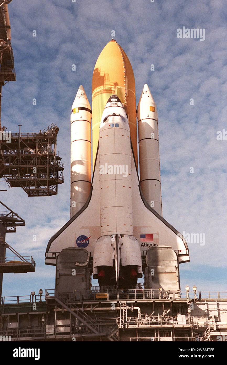 KENNEDY SPACE CENTER, FLORIDE. -- un soleil matinal brillant brille sur la navette spatiale Atlantis alors qu'elle se trouve sur le Launch Pad 39A. Devant les ailes, de chaque côté de l’orbiteur se trouvent des mâts de service de queue, qui supportent les besoins en fluide, en gaz et en électricité des ombilicaux T-0 arrière de l’orbiteur en oxygène liquide et en hydrogène liquide. Atlantis volera sur la mission STS-98, le septième vol de construction vers la Station spatiale internationale, transportant le Laboratoire américain, nommé Destiny. Le minilab dispose de cinq racks système déjà installés à l'intérieur du module. Après la livraison de l'électronique dans le laboratoire, att. Alimenté électriquement Banque D'Images