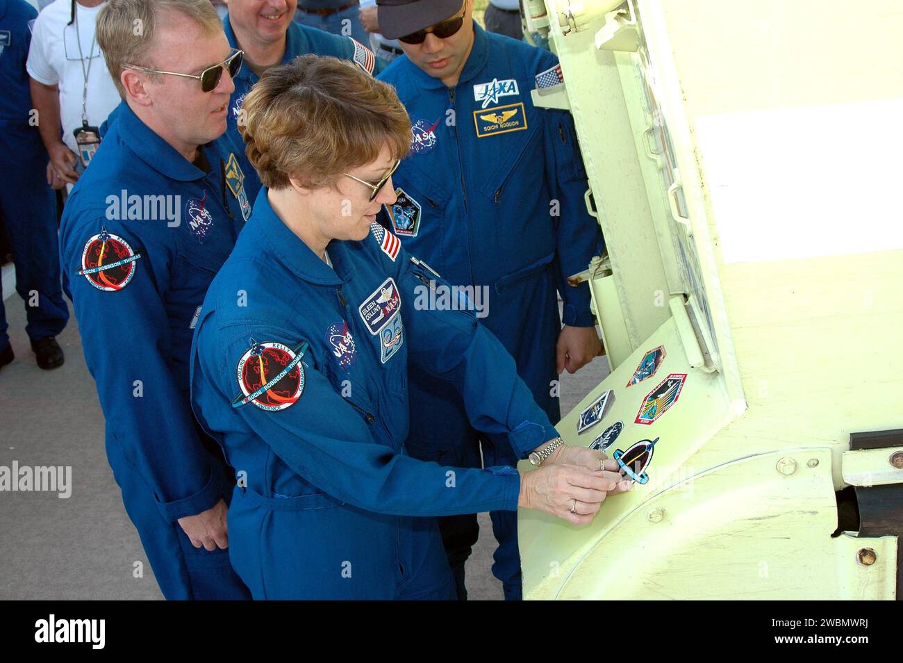 Le commandant du STS-114 Eileen Collins place un patch de mission sur un véhicule blindé de transport de troupes M-113 pendant le test de démonstration du compte à rebours terminal (TCDT) au Kennedy Space Center. Andrew Thomas, Stephen Robinson et Soichi Noguchi, membres de l'équipage, y participent. Le TCDT simule le compte à rebours et les procédures d'urgence avant les vols de navette, se terminant par un faux arrêt du moteur principal. STS-114 est la première mission de retour au vol avec une fenêtre de lancement du 13 au 31 juillet. Banque D'Images
