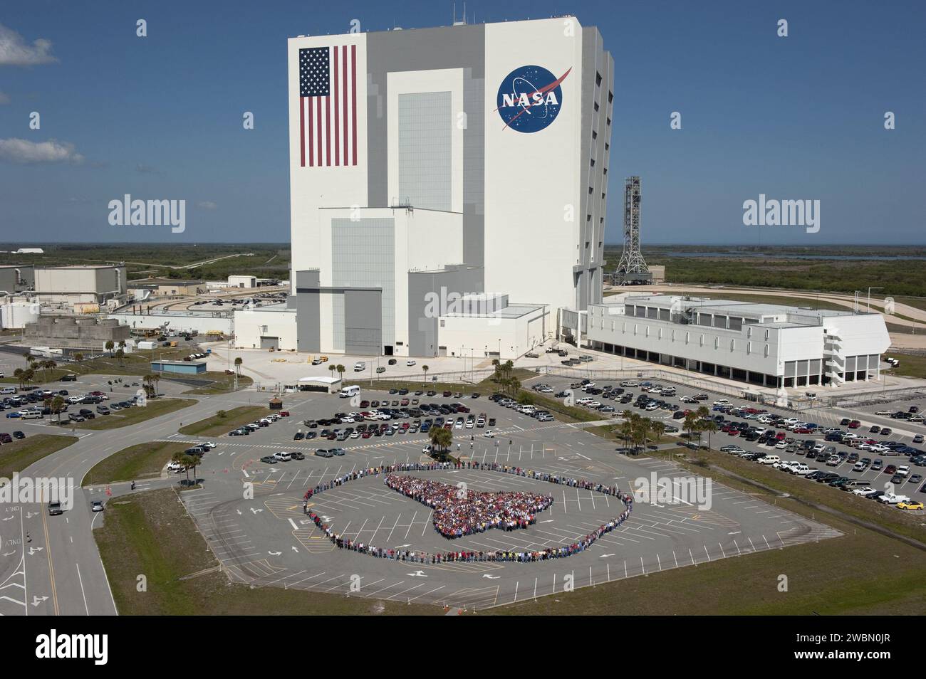 Des milliers d'employés du Kennedy Space Center ont dessiné les grandes lignes d'un orbiteur de navette spatiale à l'extérieur du bâtiment d'assemblage des véhicules pour honorer les 30 ans d'héritage du programme de navette spatiale et de sa main-d'œuvre. Banque D'Images