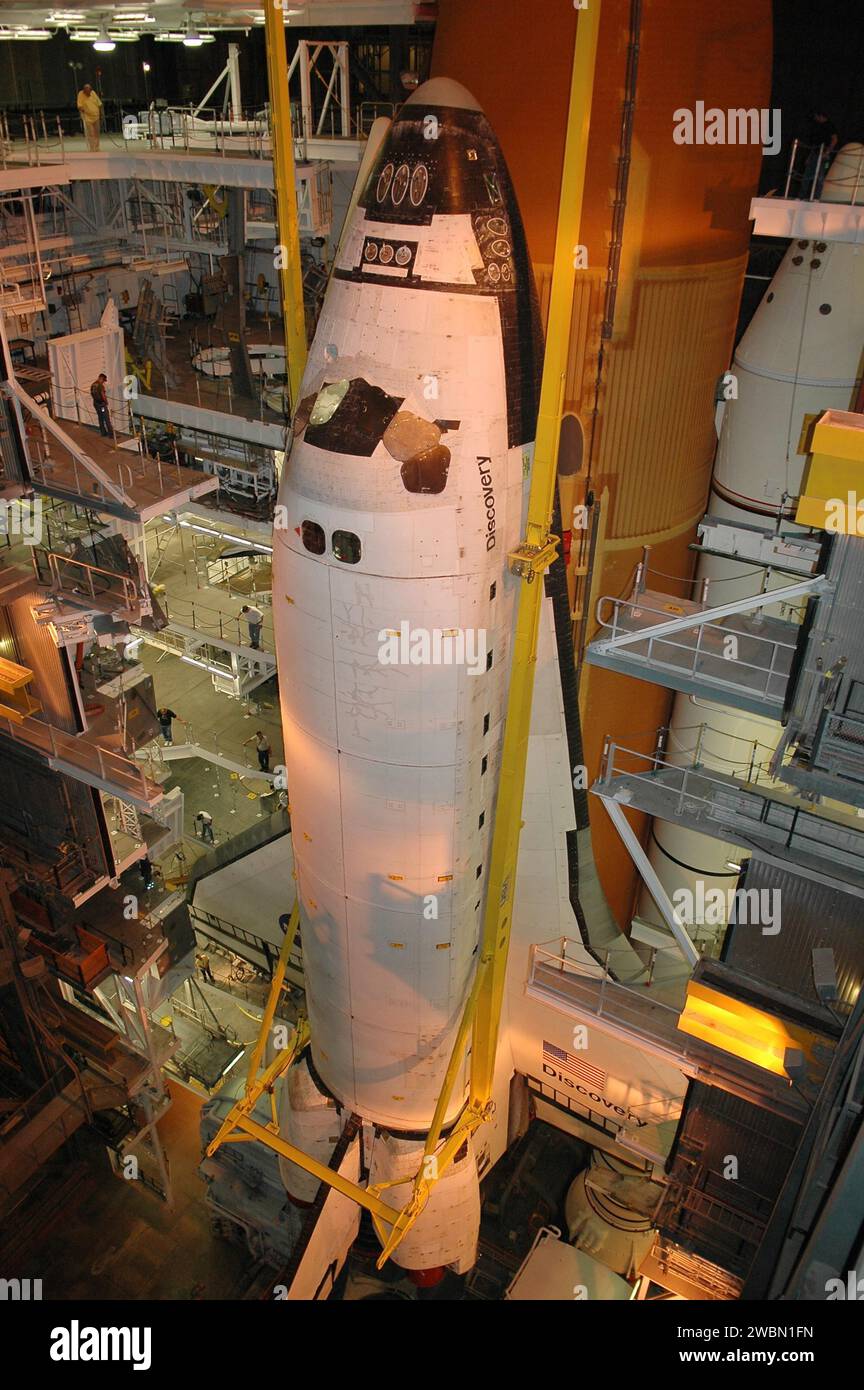 À la baie 1 du bâtiment d’assemblage de véhicules du Kennedy Space Center, les travailleurs observent l’orbiteur Discovery soulevé par une grue de son réservoir externe et de ses propulseurs de fusées solides. L'orbiteur sera transféré à la baie haute 3 pour être réorienté avec l'et-121. Discovery devrait reprendre le pas de lancement à la mi-juin pour le STS-114, avec une fenêtre de lancement du 13 au 31 juillet. Banque D'Images