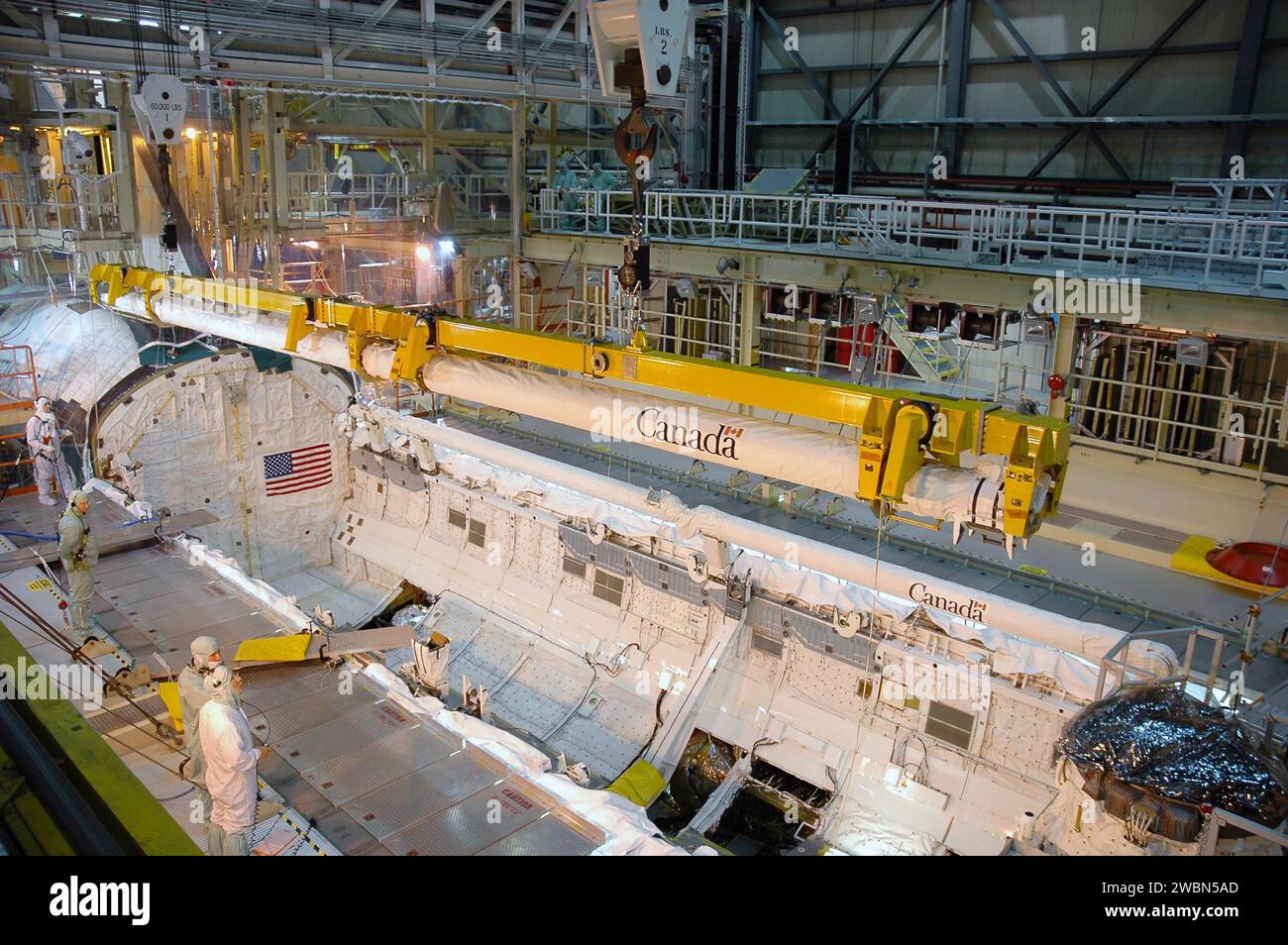 CENTRE SPATIAL KENNEDY, FLA. - Dans l’installation de traitement de l’orbiteur du Kennedy Space Center de la NASA, baie 3, le bras robotisé du système de capteur de boom orbiteur construit au Canada est retiré de la baie de charge utile de Discovery. La flèche, qui a été utilisée lors de la mission de retour en vol STS-114 pour effectuer une inspection plus approfondie et photographier Discovery, fera l'objet d'une inspection. L'orbiteur sera traité pour la deuxième mission de retour en vol, STS-121. Banque D'Images