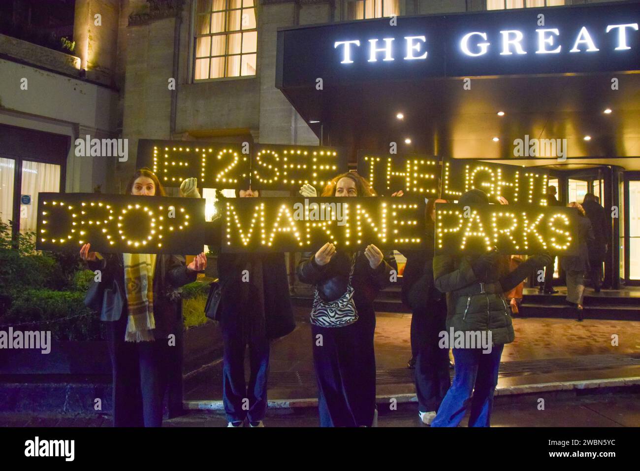 Londres, Royaume-Uni. 11 janvier 2024. Les militants de PETA organisent une manifestation devant les Globe Travel Awards à l’hôtel JW Marriott Grosvenor dans Park Lane à Londres, tenant des panneaux lumineux indiquant « Jet2, See the Light, Drop Marine Parks ». L’action fait partie de la campagne en cours de PETA exhortant Jet2, le plus grand voyagiste du Royaume-Uni, à abandonner les parcs marins qui retiennent les cétacés captifs de ses forfaits vacances. Crédit : Vuk Valcic/Alamy Live News Banque D'Images