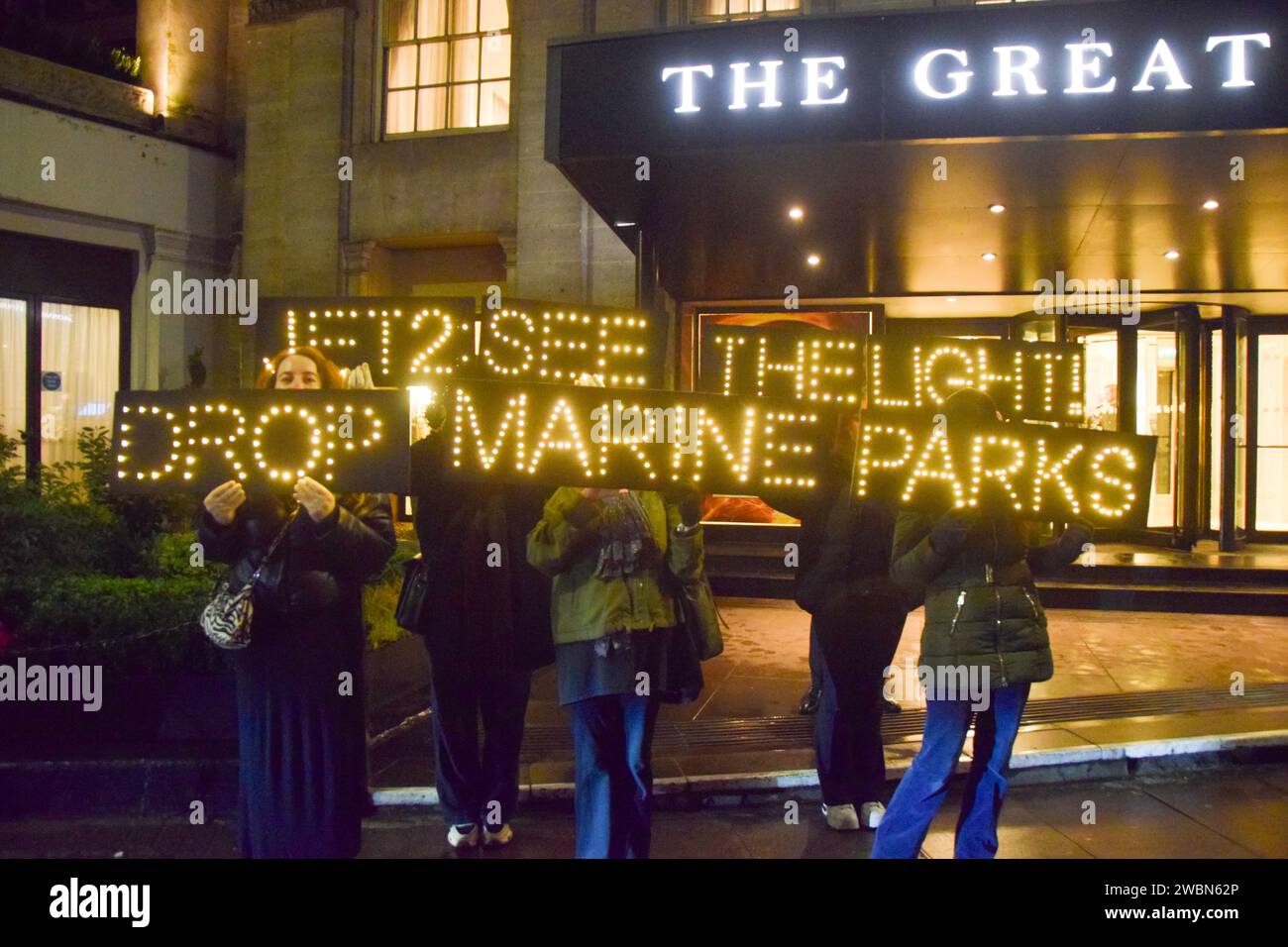 Londres, Royaume-Uni. 11 janvier 2024. Les militants de PETA organisent une manifestation devant les Globe Travel Awards à l’hôtel JW Marriott Grosvenor dans Park Lane à Londres, tenant des panneaux lumineux indiquant « Jet2, See the Light, Drop Marine Parks ». L’action fait partie de la campagne en cours de PETA exhortant Jet2, le plus grand voyagiste du Royaume-Uni, à abandonner les parcs marins qui retiennent les cétacés captifs de ses forfaits vacances. Crédit : Vuk Valcic/Alamy Live News Banque D'Images