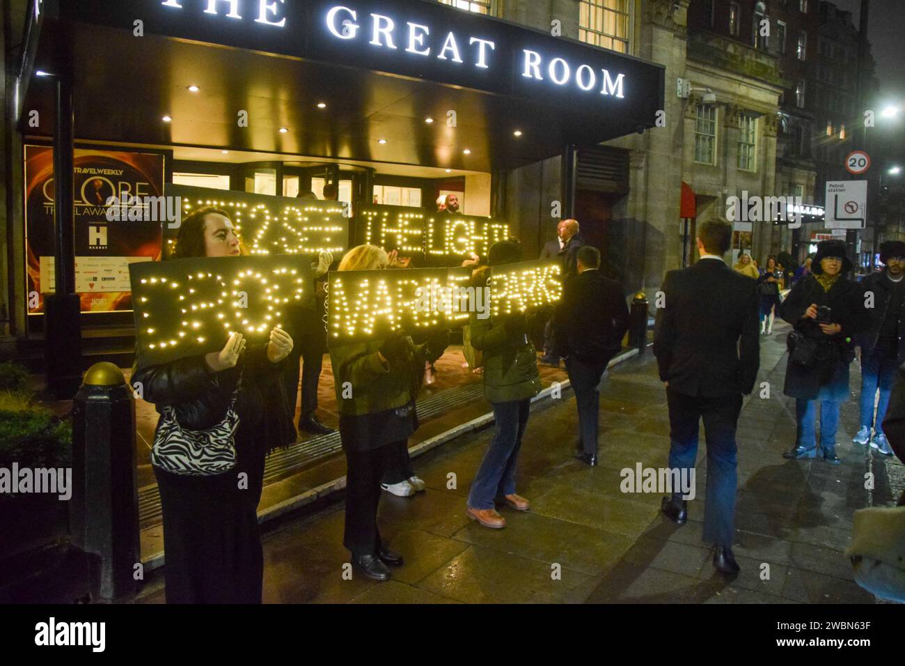 Londres, Royaume-Uni. 11 janvier 2024. Les militants de PETA organisent une manifestation devant les Globe Travel Awards à l’hôtel JW Marriott Grosvenor dans Park Lane à Londres, tenant des panneaux lumineux indiquant « Jet2, See the Light, Drop Marine Parks ». L’action fait partie de la campagne en cours de PETA exhortant Jet2, le plus grand voyagiste du Royaume-Uni, à abandonner les parcs marins qui retiennent les cétacés captifs de ses forfaits vacances. Crédit : Vuk Valcic/Alamy Live News Banque D'Images