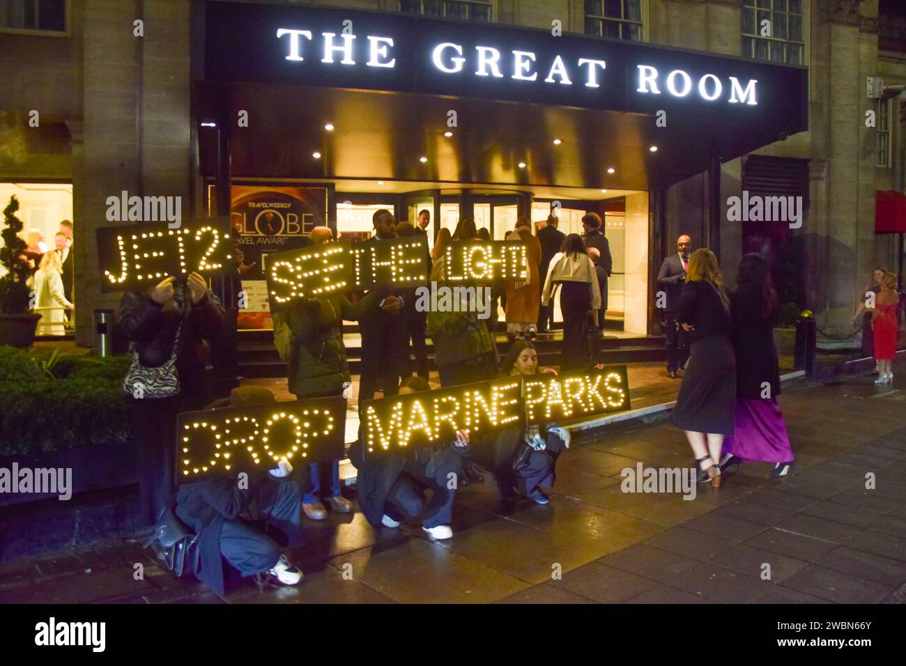 Londres, Royaume-Uni. 11 janvier 2024. Les militants de PETA organisent une manifestation devant les Globe Travel Awards à l’hôtel JW Marriott Grosvenor dans Park Lane à Londres, tenant des panneaux lumineux indiquant « Jet2, See the Light, Drop Marine Parks ». L’action fait partie de la campagne en cours de PETA exhortant Jet2, le plus grand voyagiste du Royaume-Uni, à abandonner les parcs marins qui retiennent les cétacés captifs de ses forfaits vacances. Crédit : Vuk Valcic/Alamy Live News Banque D'Images