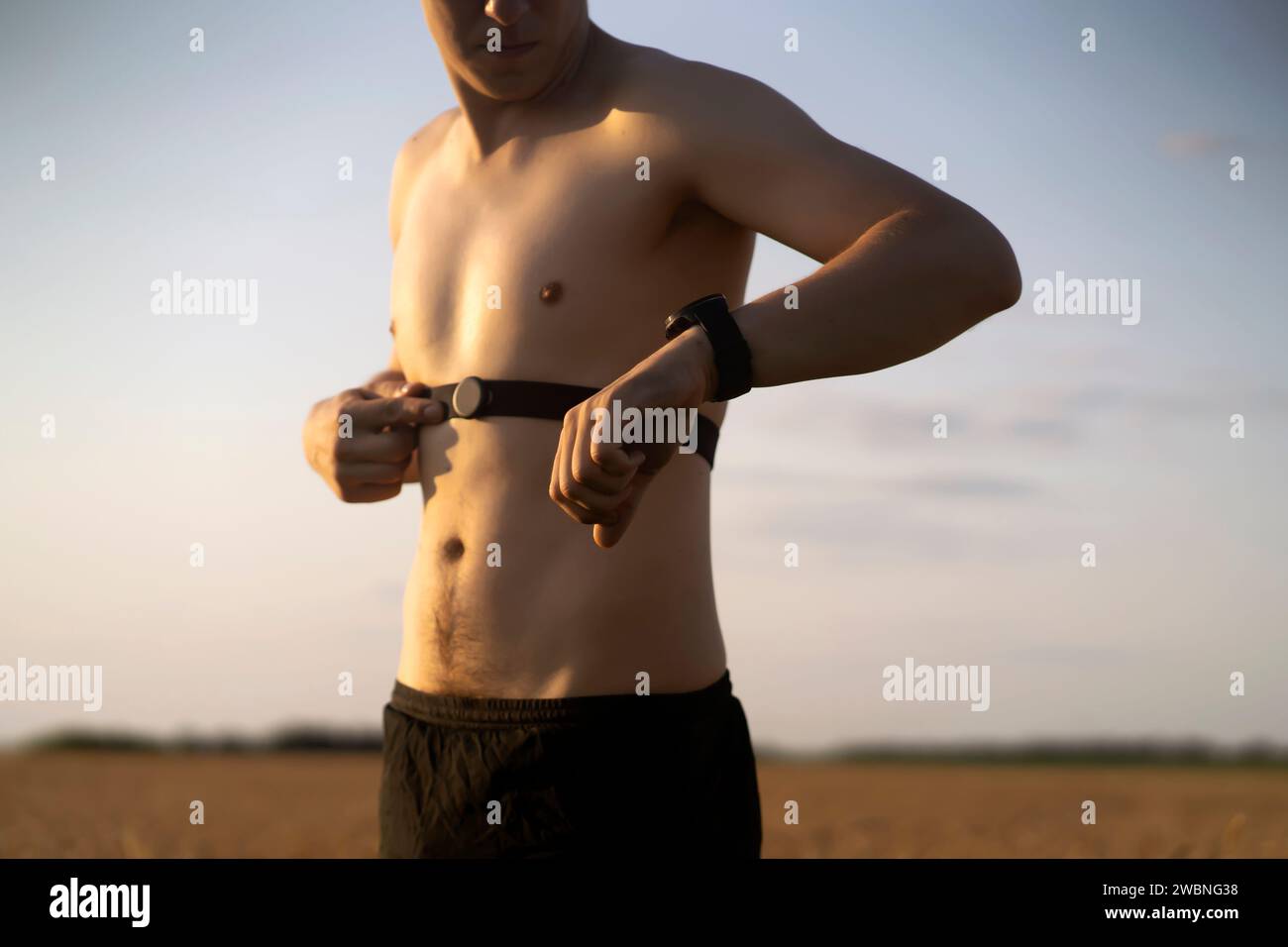 L'homme porte un moniteur de fréquence cardiaque avant sa course et son entraînement par jogging. Banque D'Images