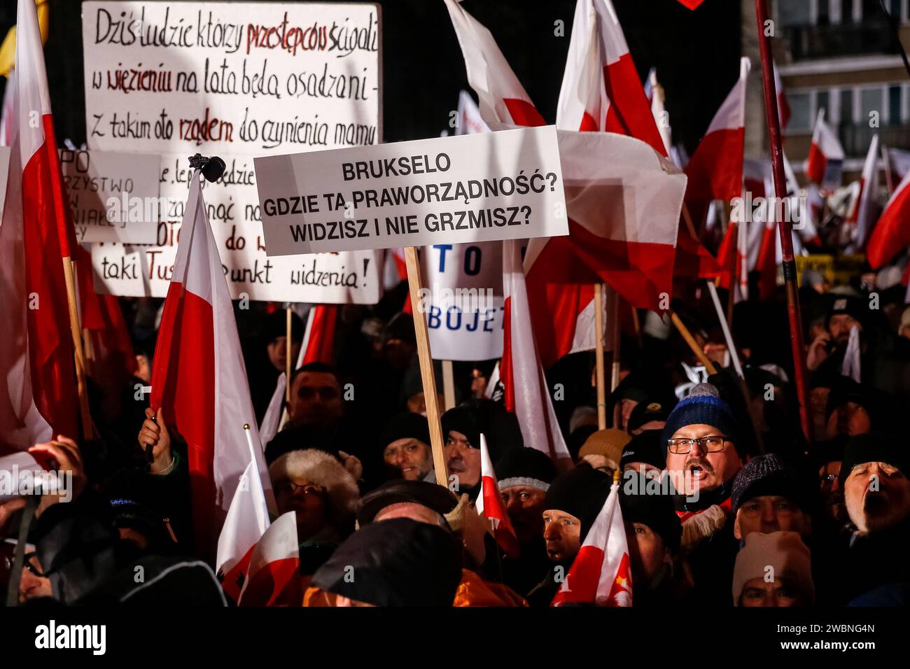 Varsovie, Pologne, 11 janvier 2024. Des foules, brandissant des drapeaux nationaux polonais et une banderole qui dit "Bruxelles - où est votre État de droit?", dirigée par droit et Justice (Prawo i Sprawiedliwość - pis) les dirigeants des partis politiques protestent devant le bâtiment du Parlement polonais contre les changements dans les médias publics en Pologne et dans la protection de la démocratie - disent les politiciens du pis. Le parti droit et Justice a régné en Pologne pendant 8 ans jusqu'à ce qu'ils perdent les dernières élections en octobre 2023. Le parti devient maintenant une force d'opposition de droite contre une coalition dirigeante plus centriste et libérale, où le principal po Banque D'Images