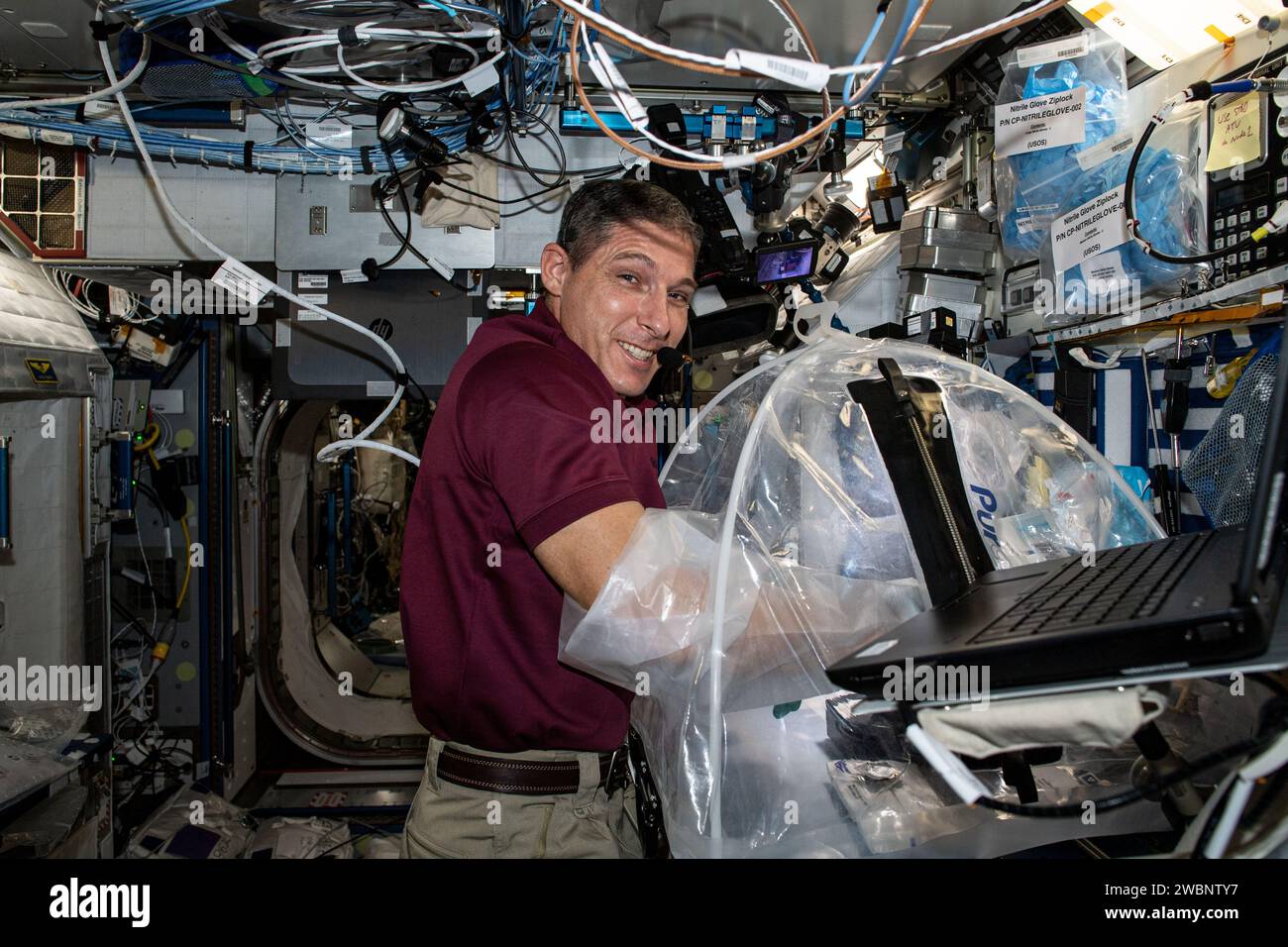 L'astronaute de la NASA et ingénieur de vol de l'expédition 64 Michael Hopkins réalise l'expérience HemoCue à l'intérieur d'un sac à gants portable le 28 décembre 2020, afin de vérifier les capacités autonomes d'analyse de sang en microgravité pour la recherche médicale. Banque D'Images