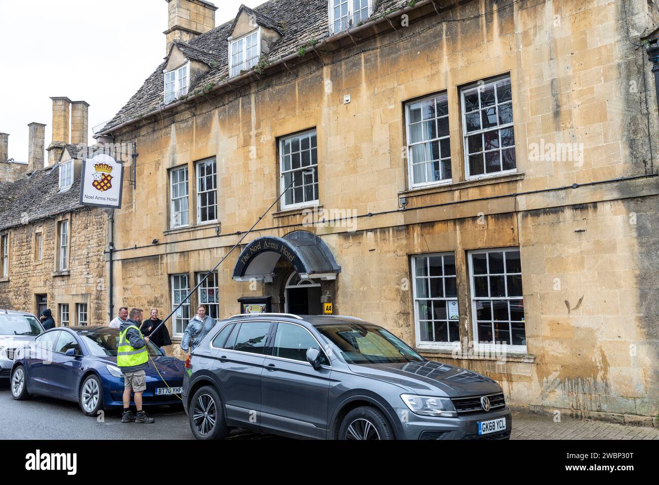 Chipping Campden ancienne ville de marché, Noel House Hôtel dans la rue haute inférieure, homme de nettoyage des fenêtres, pub et hôtel, Angleterre, Royaume-Uni, 2023 Banque D'Images