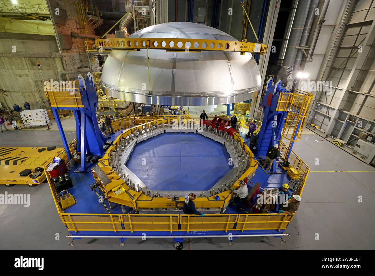 Le 6 décembre 2023, les techniciens de la NASA à Michoud Assembly Facility ont déplacé le dôme arrière du réservoir d'oxygène liquide de la fusée SLS à l'intérieur du vertical Assembly Center. Le dôme joindra les segments avant et arrière du canon par soudage par friction-agitation, faisant partie de l'étage central de 212 pieds pour Artemis III. L'étage central comprend la jupe avant, l'interréservoir, le réservoir d'hydrogène liquide, la section moteur et quatre moteurs RS-25. Banque D'Images