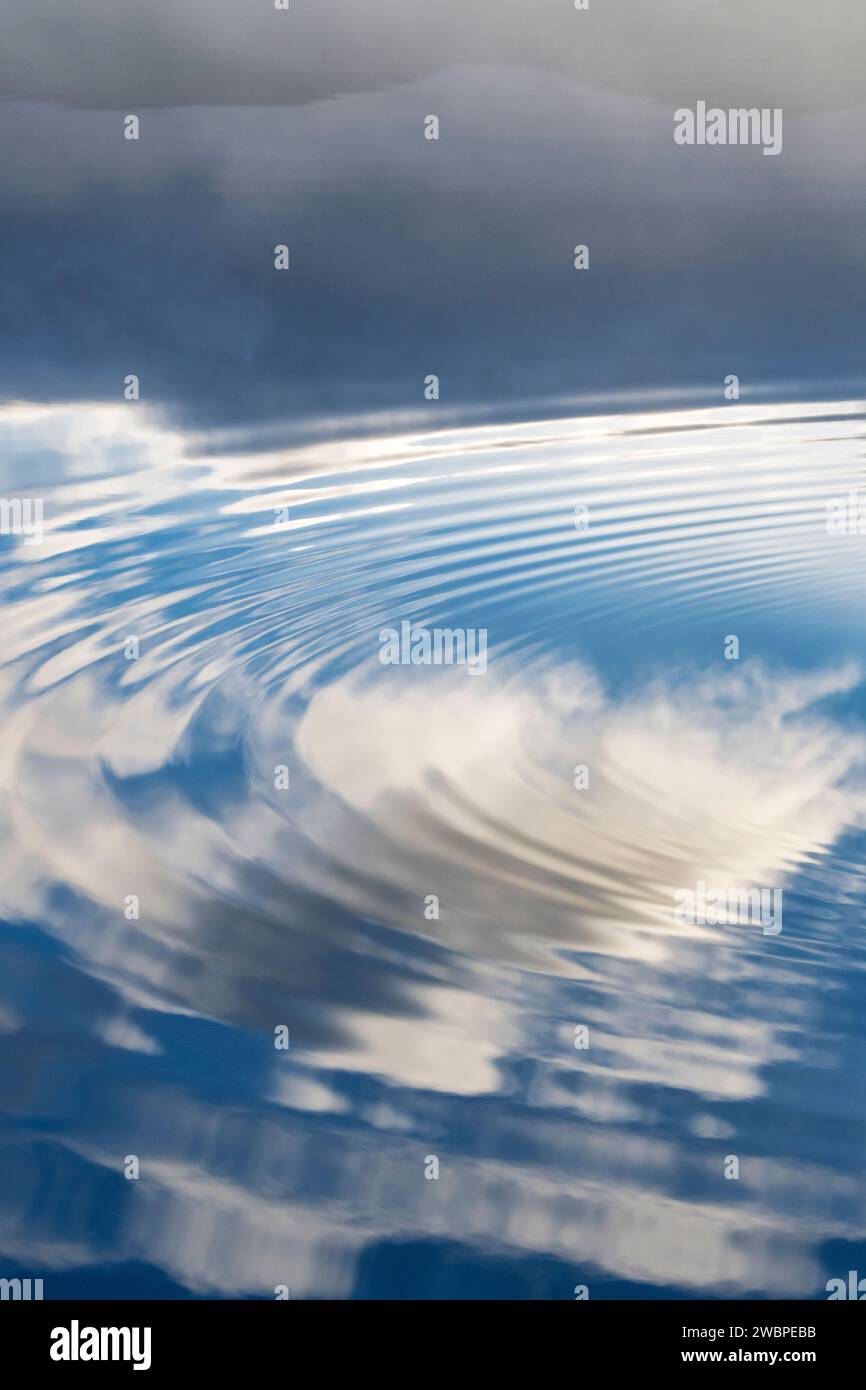 Nuages se reflétant dans un loch immobile avec des ondulations. Highlands, Écosse Banque D'Images