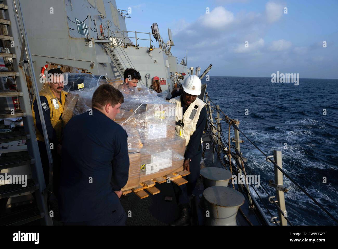 231221-N-CK669-1104 RED SEA (21 décembre 2023) Bryan Barnaby, spécialiste en chef de la logistique, à droite, dirige un groupe de marins transportant une palette de fournitures à bord du destroyer de missiles guidés de classe Arleigh Burk USS Mason (DDG 87) lors d'un réapprovisionnement en mer avec le graisseur de réapprovisionnement de la flotte de classe Henry J. Kaiser USNS Kanawha (T-AO 196) en mer Rouge alors que Mason opère en soutien à l'opération Prosperity Guardian (OPG), décembre 21. Dirigé par la Force opérationnelle combinée 153 des Forces maritimes combinées, OPG représente un effort international ciblé pour relever les défis de la sécurité maritime dans le sud de la mer Rouge Banque D'Images