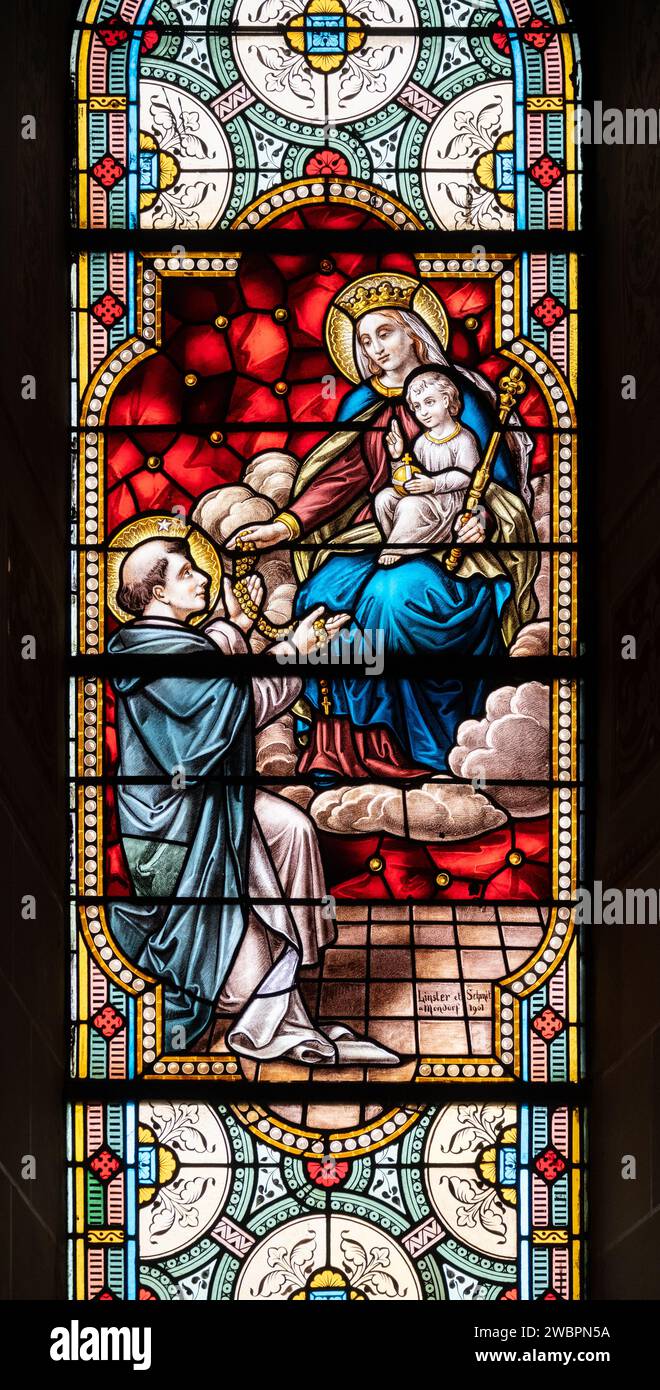 Saint Dominique recevant le rosaire de la Vierge Marie. Un vitrail dans l'église de la Sainte-Trinité à Walferdange. Banque D'Images