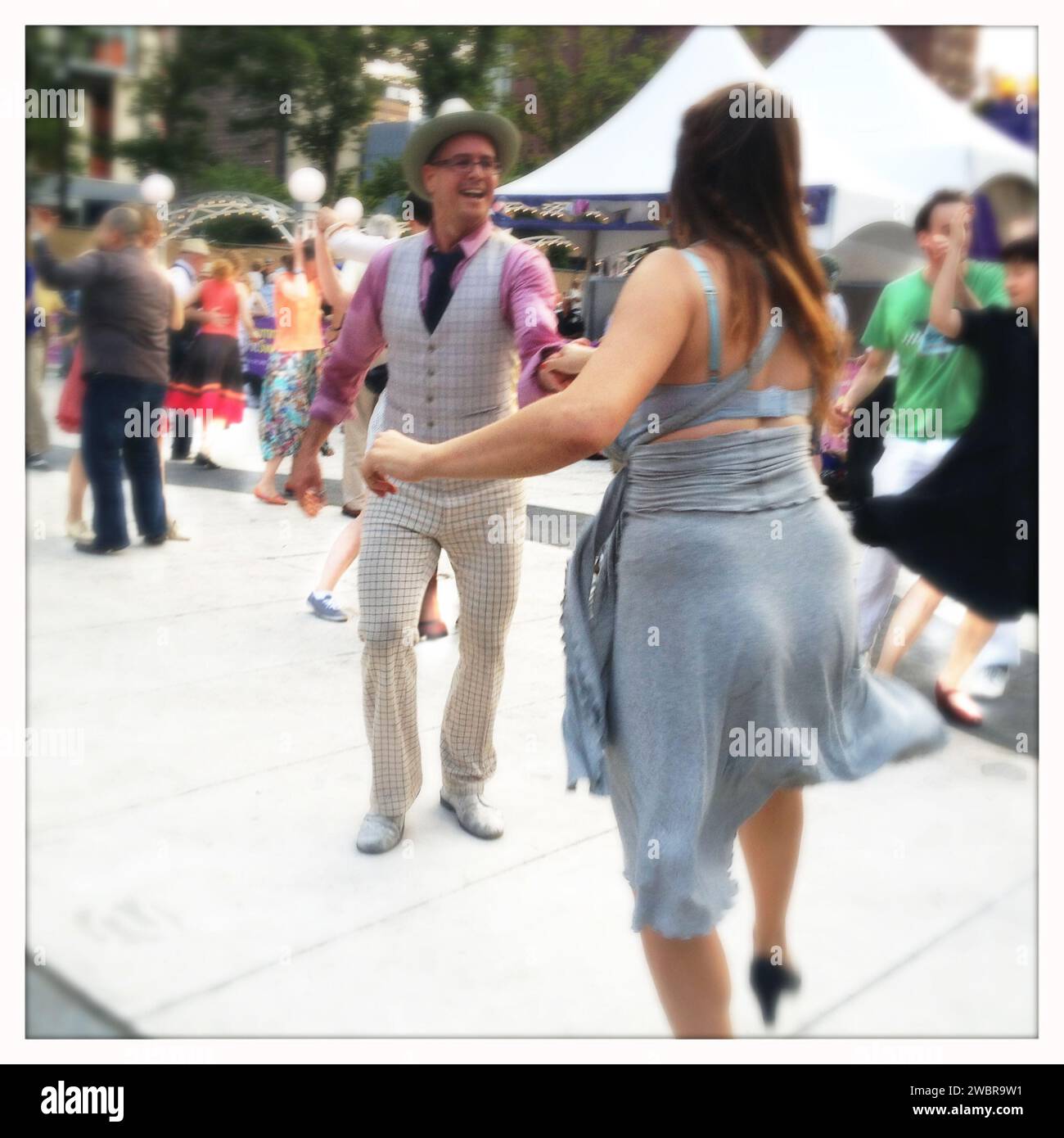 Homme en costume à carreaux lumineux dansant le boogie Woogie avec femme en bleu Banque D'Images